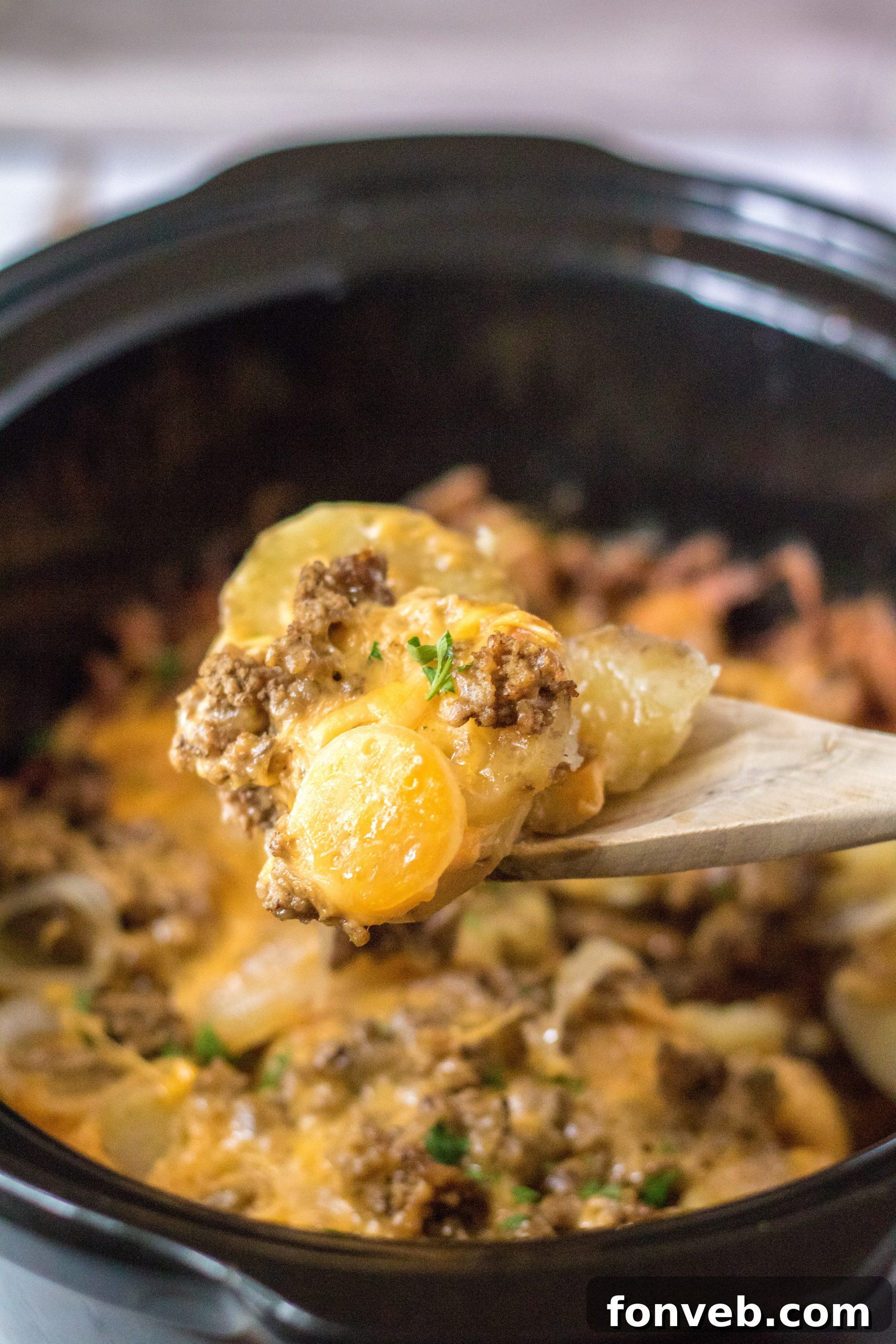 A close-up of the bubbly, melted cheese topping on the Slow Cooker Beef and Potato Au Gratin, fresh out of the crockpot.