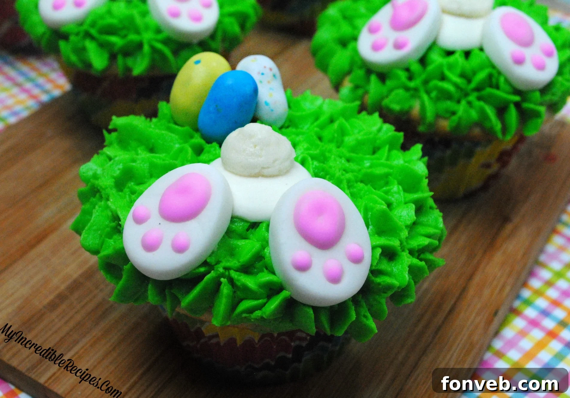 Adorable bunny butt cupcakes nestled in green frosting grass, a perfect Easter treat.