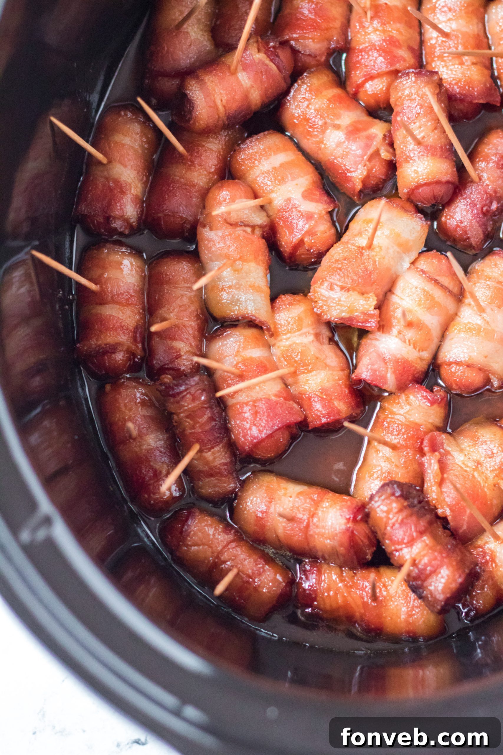A beautifully arranged serving of Slow Cooker Bacon Wrapped Smokies on a white plate.