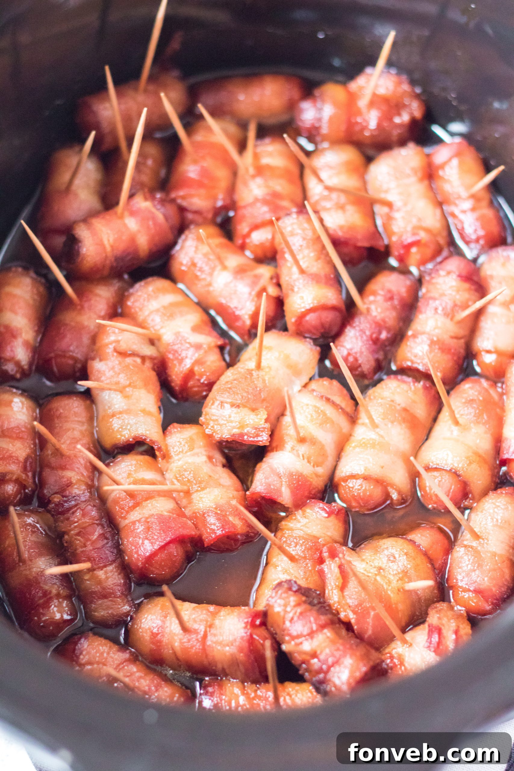 An overhead shot of a platter of Slow Cooker Bacon Wrapped Smokies, appealing to party-goers.