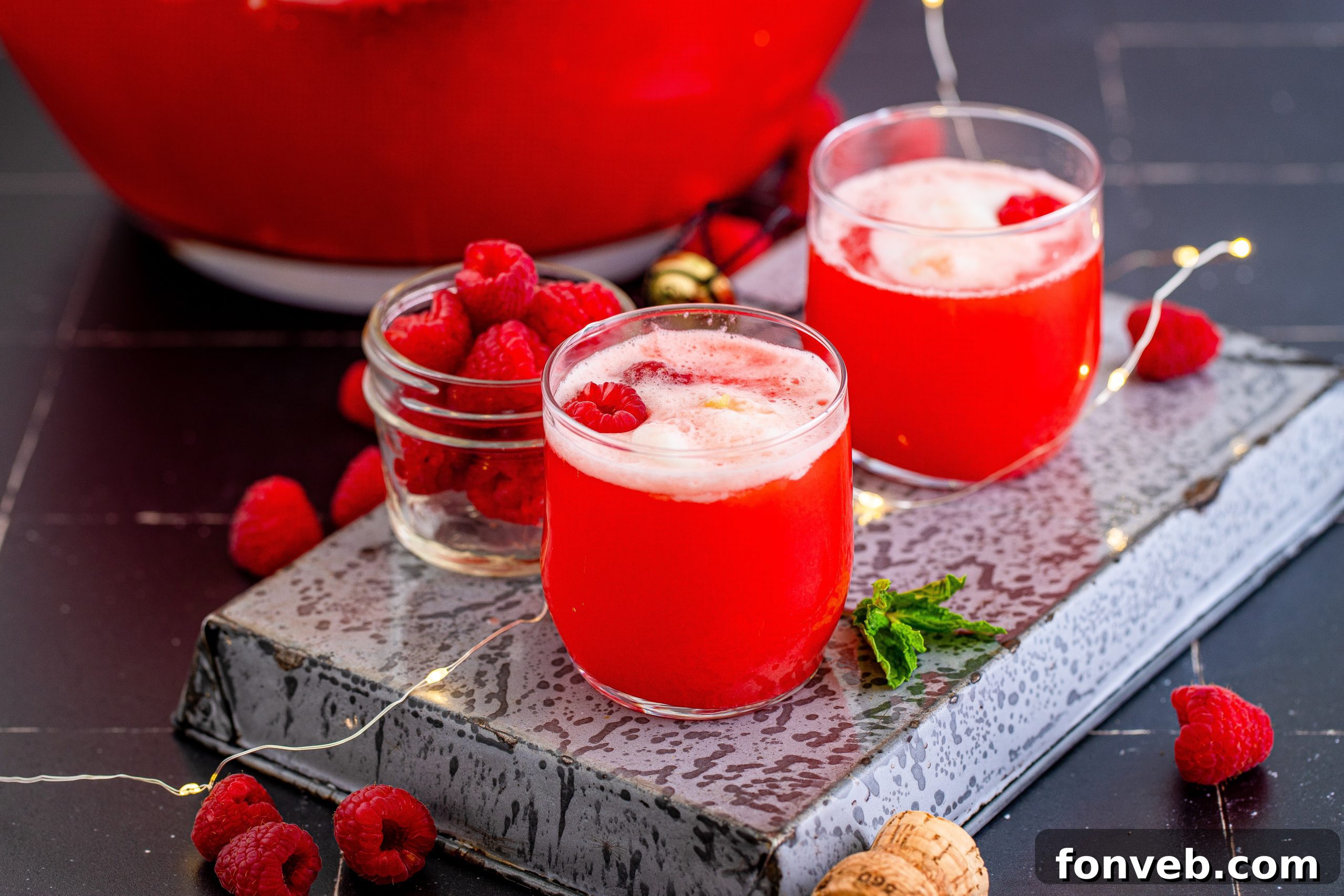 A bowl of boozy sherbet punch with several bottles of liquor in the background, suggesting customization.