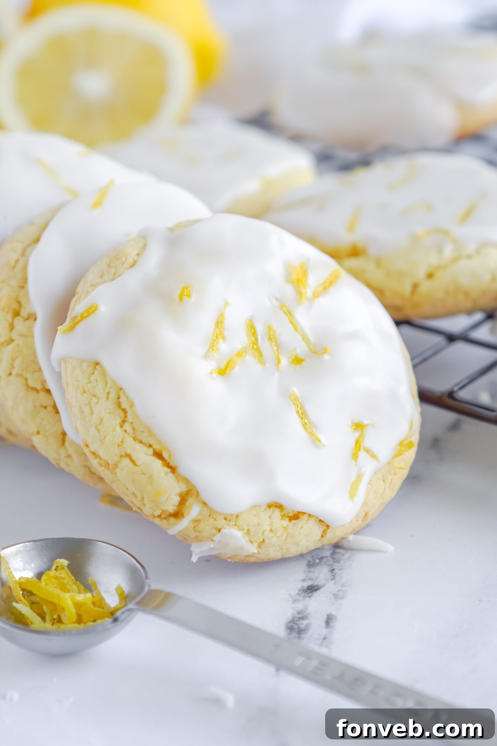Several lemon cake mix cookies with glaze, beautifully arranged on a rustic background, inviting you to take a bite.
