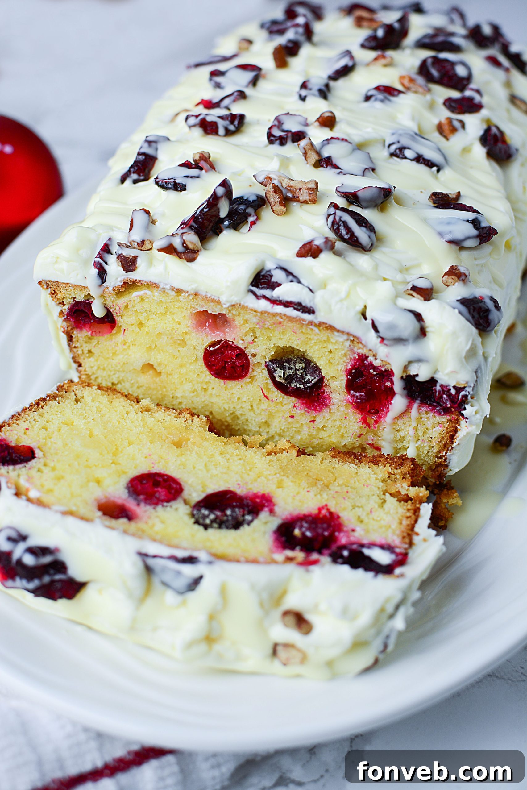 Crimson Cranberry Holiday Cake 2 Beautifully sliced Christmas Cranberry Pound Cake topped with cream cheese frosting and fresh cranberries.