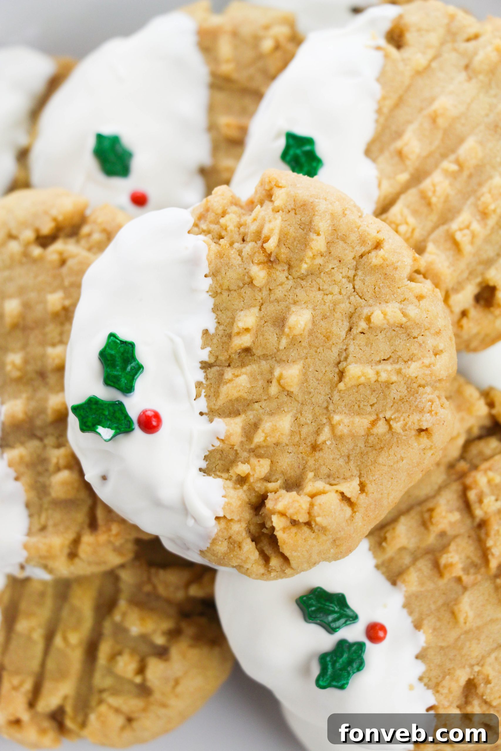 Pile of soft and chewy white chocolate dipped peanut butter cookies, dusted with sprinkles