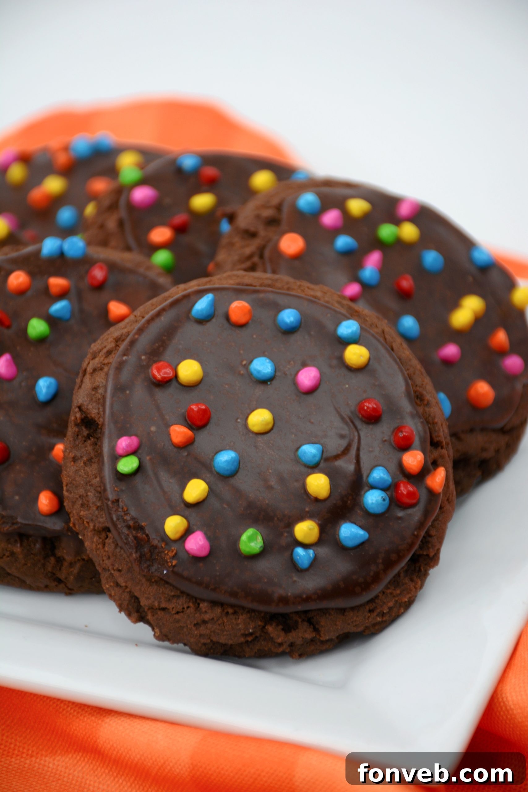 Stack of Cosmic Brownie Cookies showing the thick chocolate frosting and sprinkles.