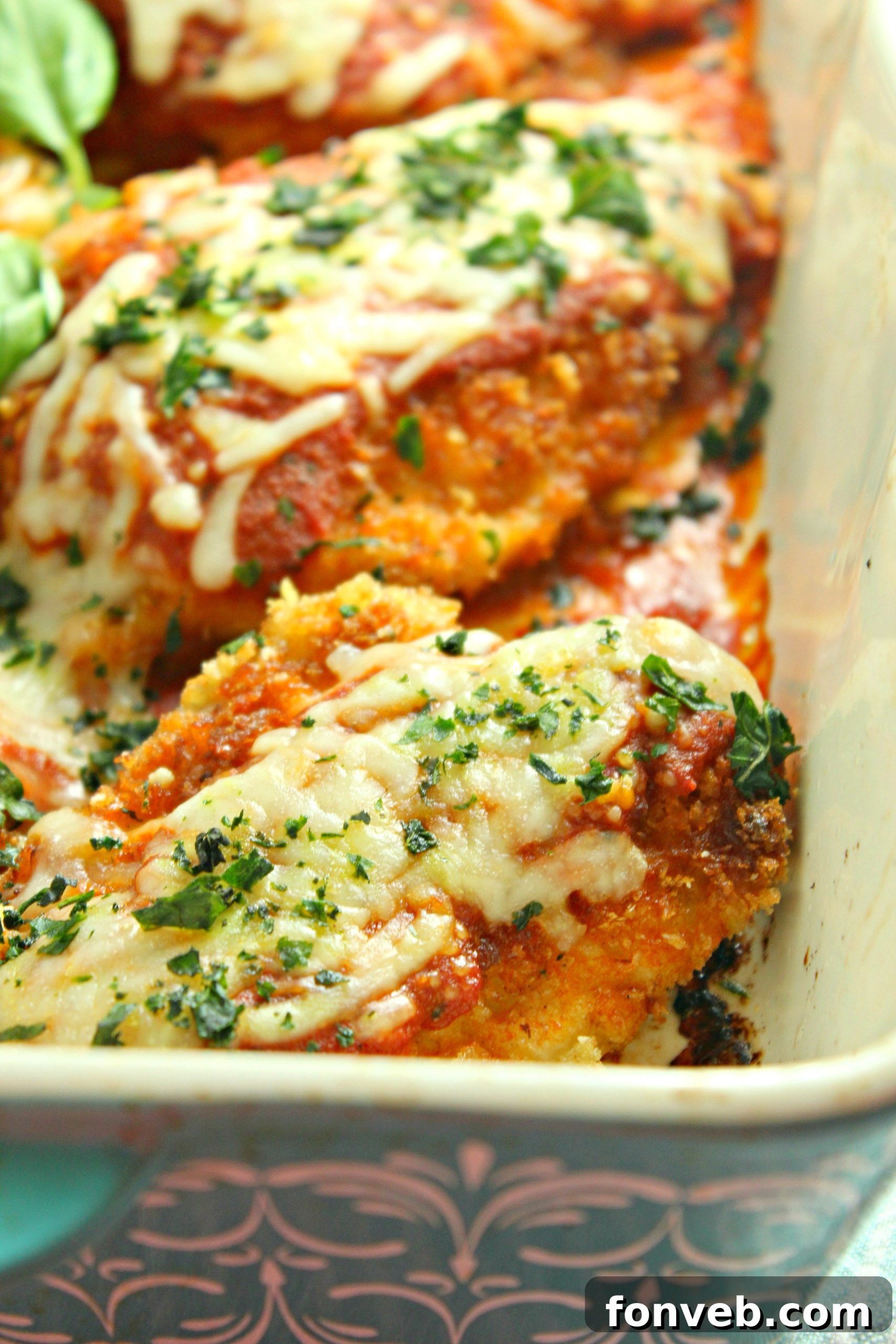 A serving of Chicken Parmesan on a plate, ready to eat.