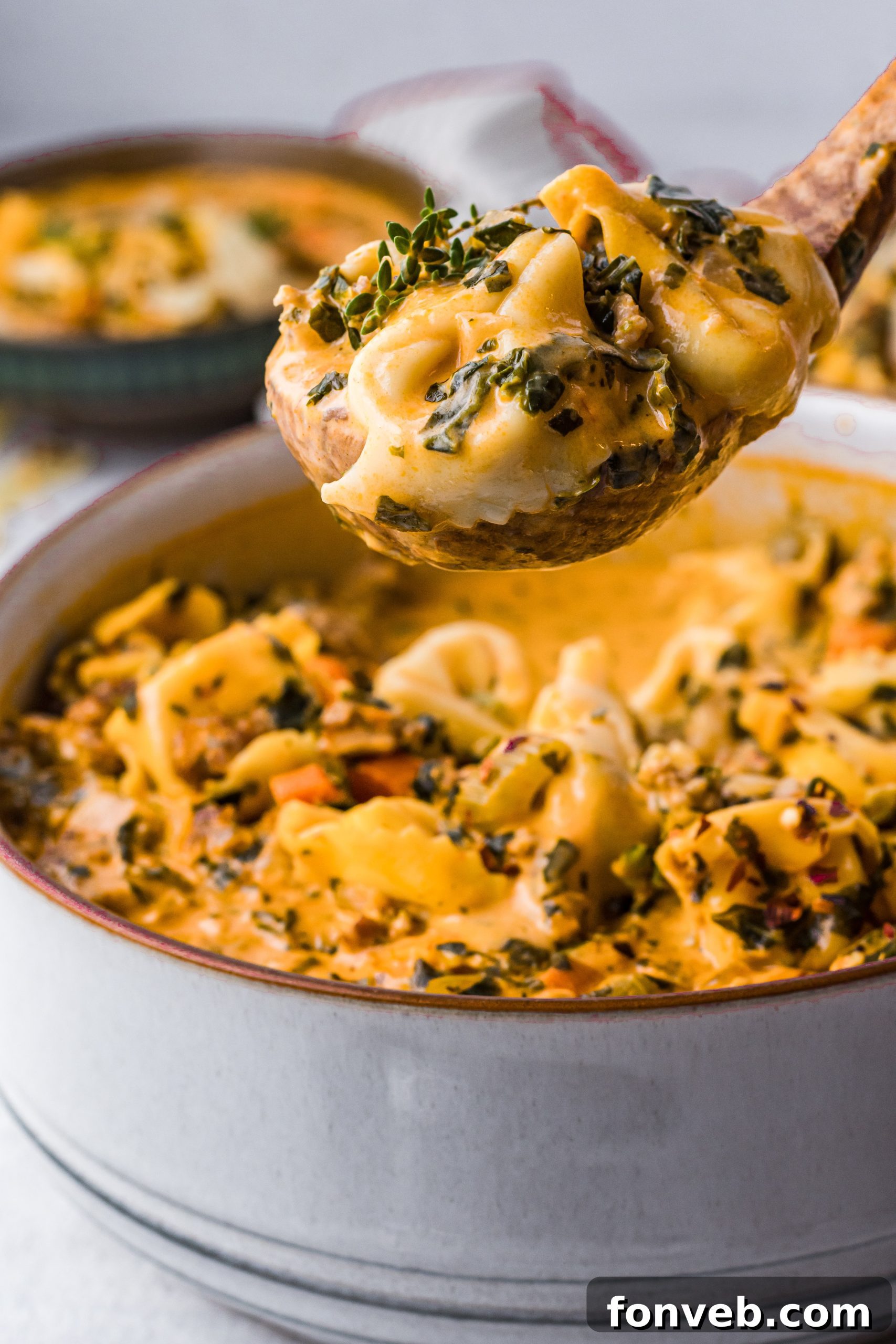 A bowl of creamy tortellini soup with Italian sausage and fresh herbs
