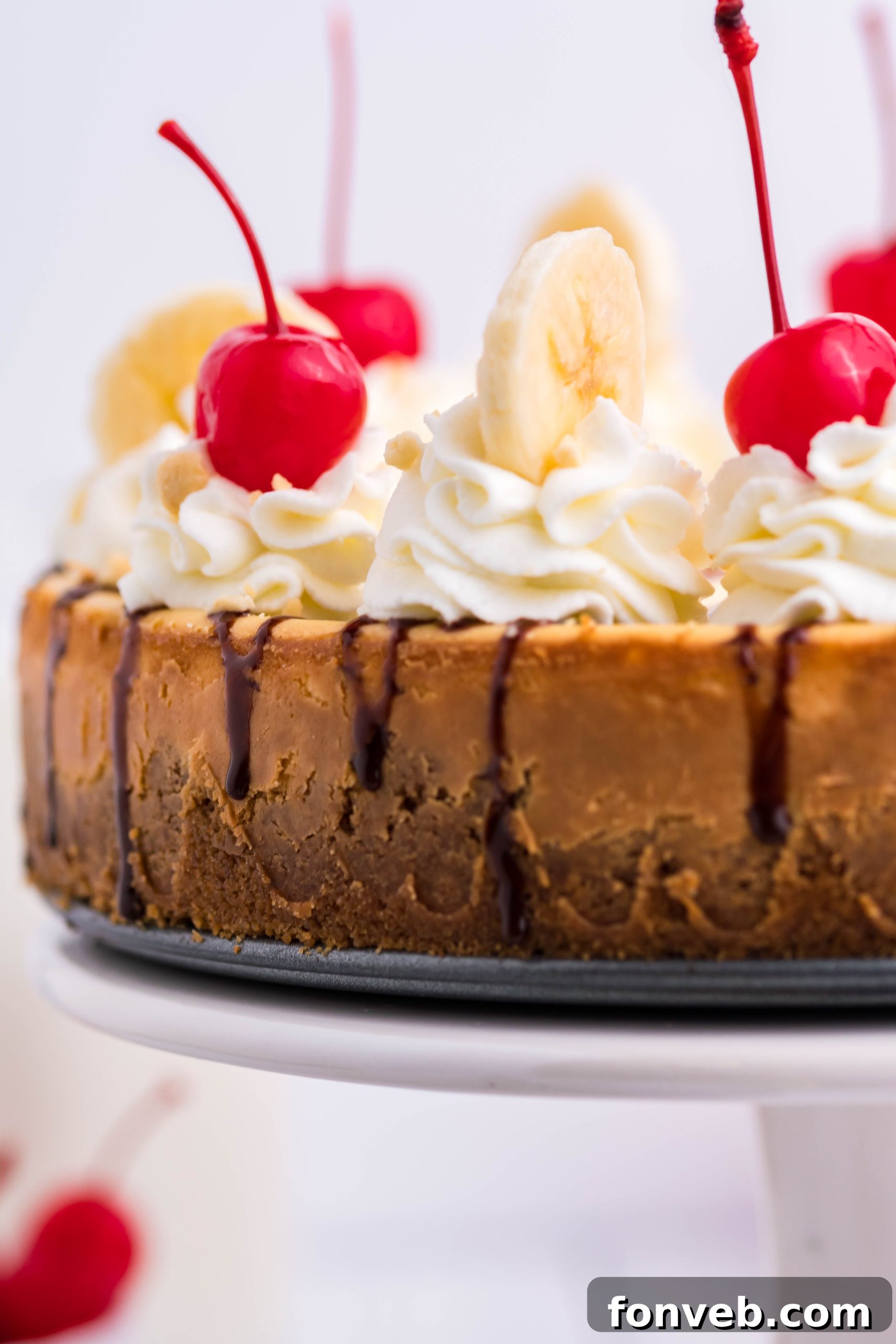 A plate with a single slice of Banana Split Cheesecake, garnished and ready to eat.