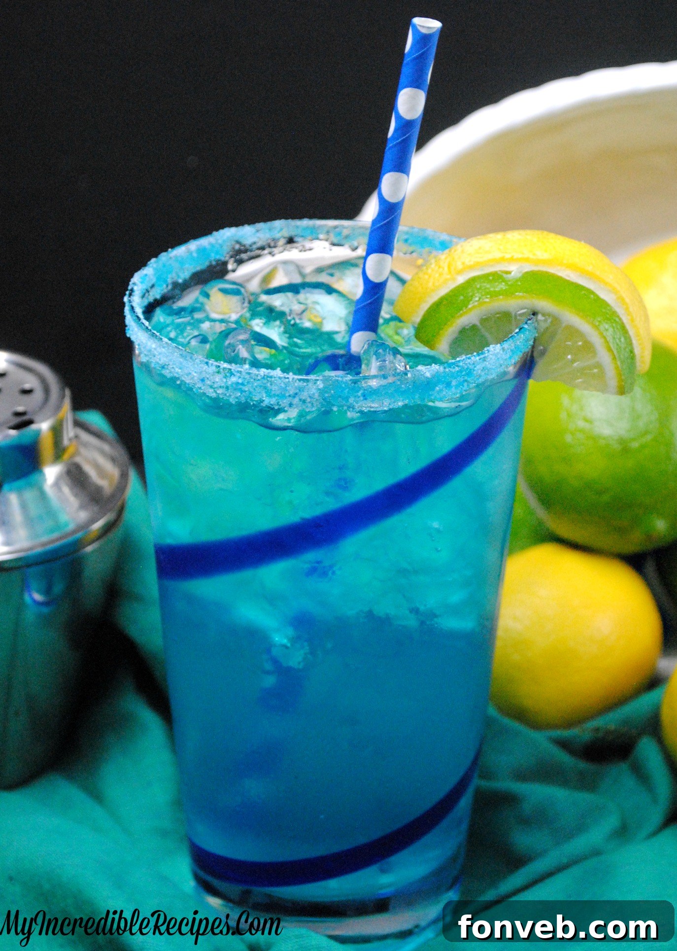 A hand holding a tall, frosted glass of Electric Lemonade, with a vibrant blue liquid and lemon slices, against a softly blurred background, highlighting its refreshing appeal