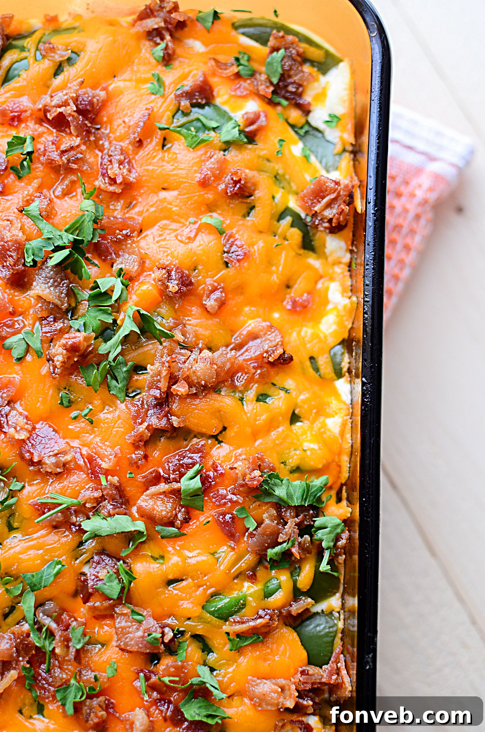 A casserole dish filled with the uncooked Jalapeño Popper Chicken Casserole mixture, topped with cheese and jalapeños.