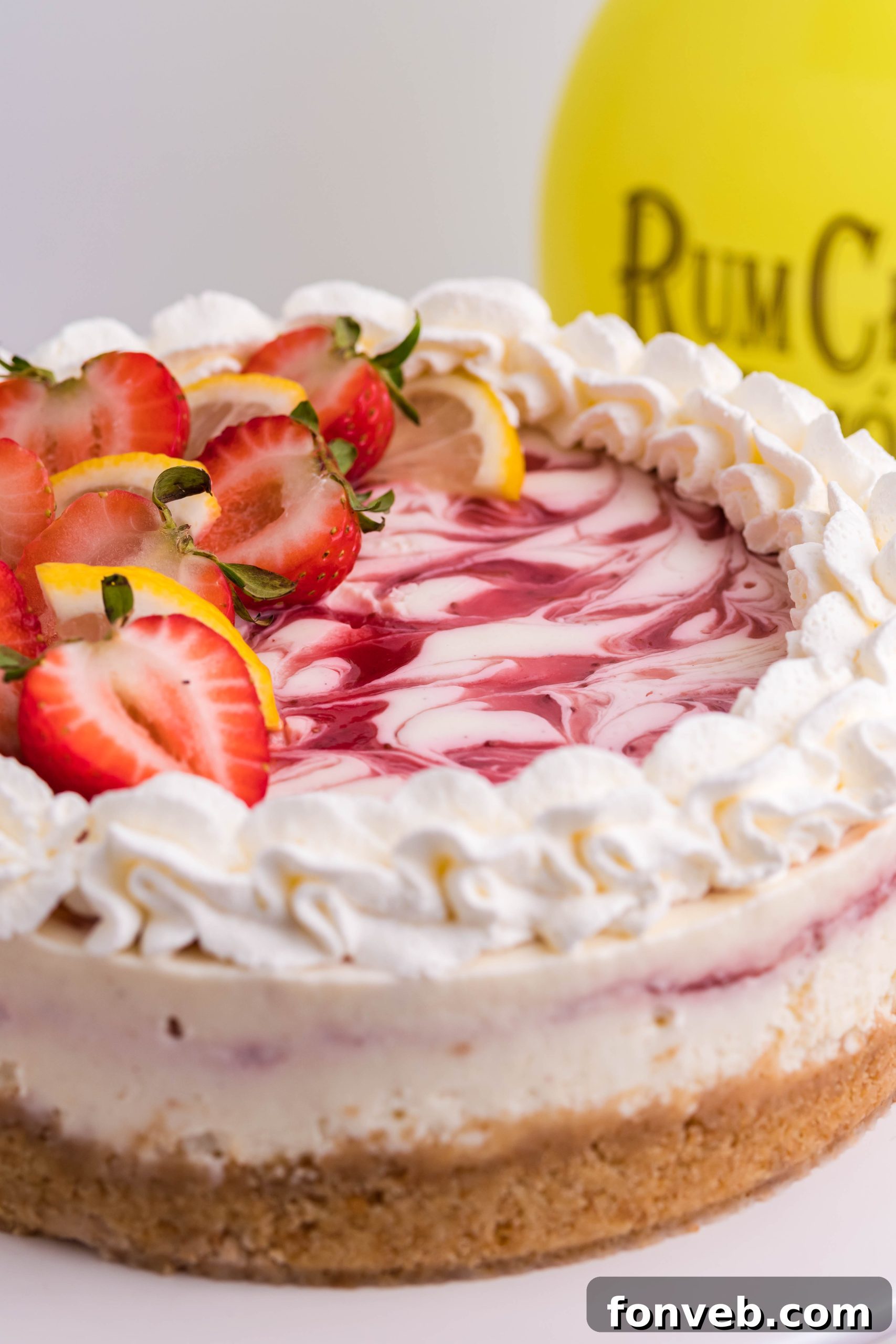 A beautifully decorated Strawberry Lemon RumChata Cheesecake, ready for serving.
