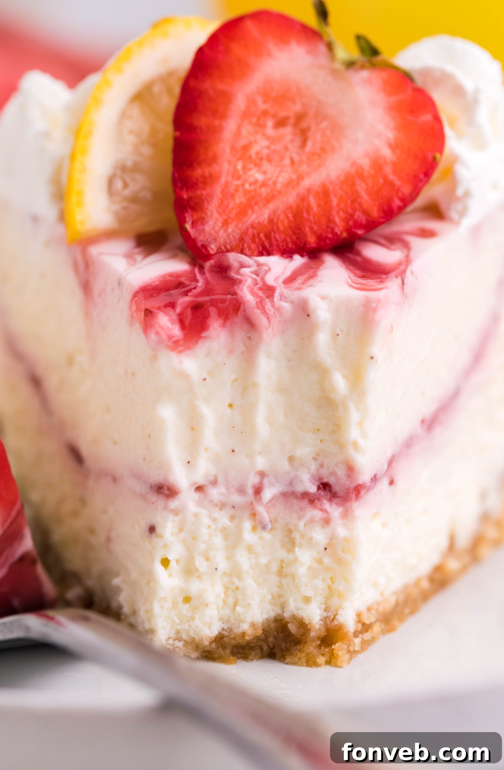 Close-up shot of the cheesecake, highlighting its smooth texture and strawberry swirl.