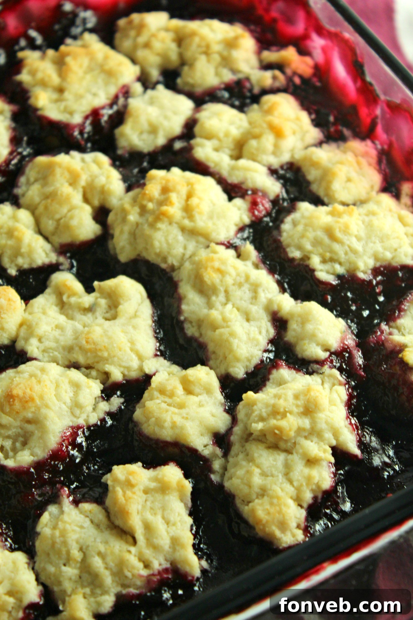 A close-up of blackberry cobbler being served with a spoon.