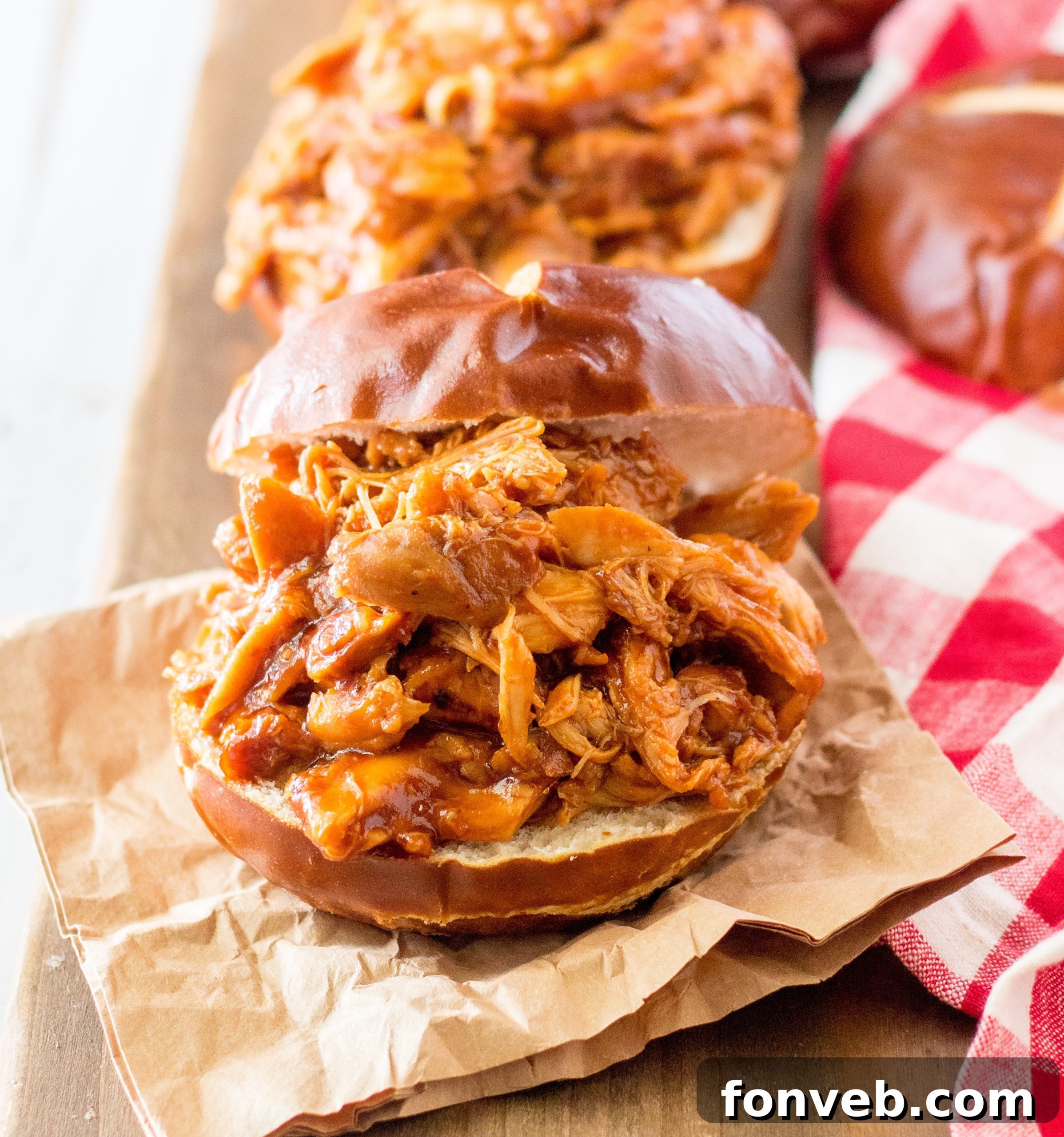 Slow Cooker Root Beer Chicken piled high on a bun, showing tender, shredded chicken