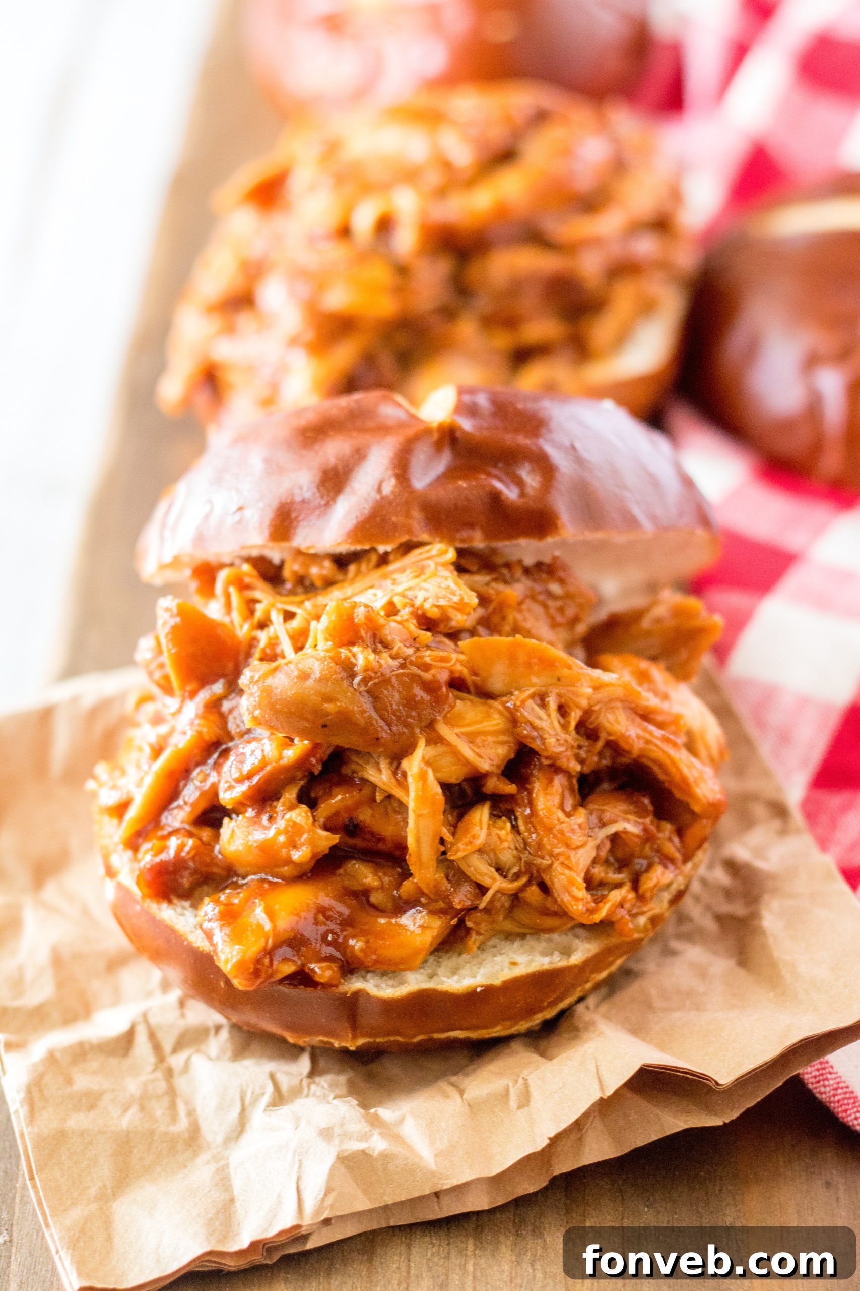 Slow Cooker Root Beer Chicken served on a bun with chips and coleslaw
