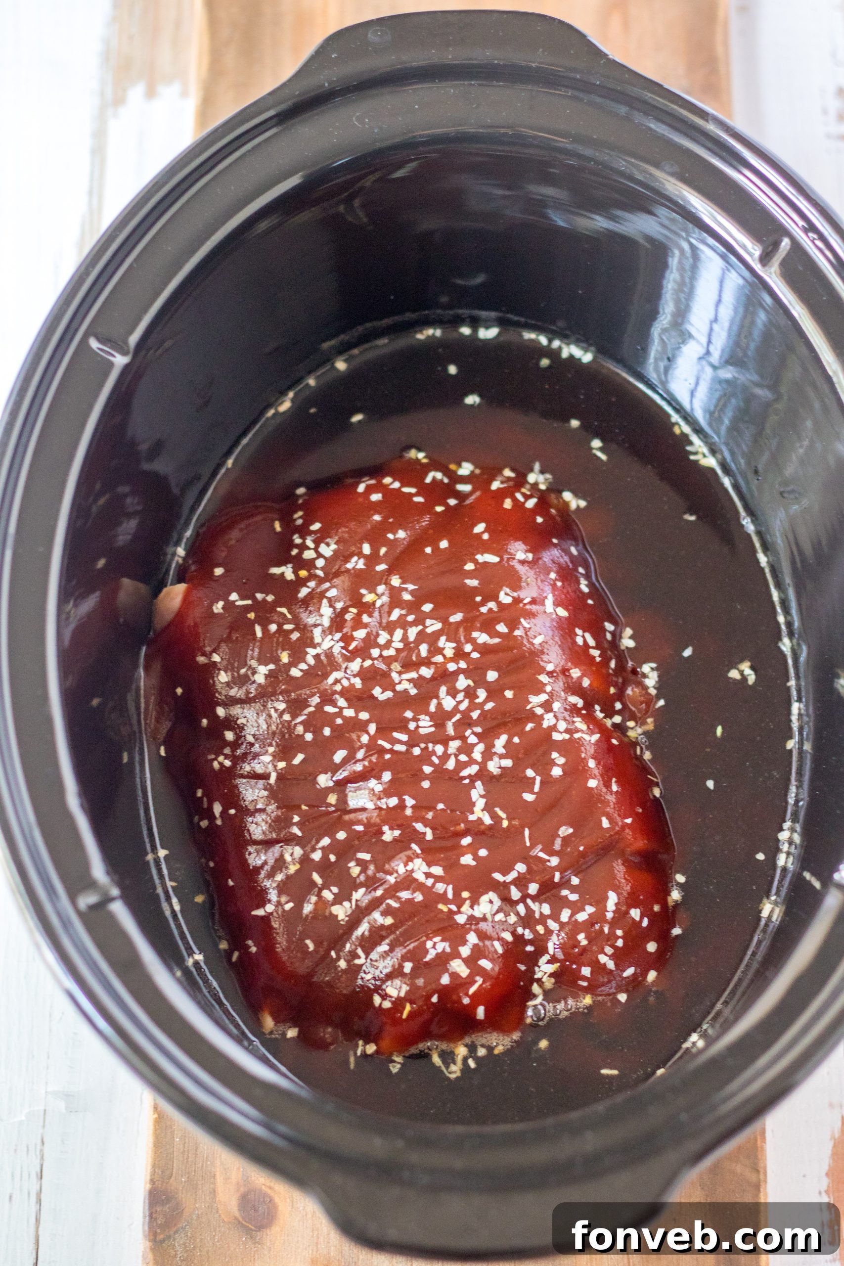 Slow Cooker Root Beer Chicken being stirred in the slow cooker
