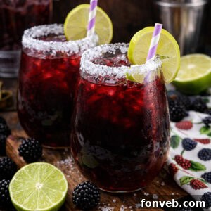 Blackberry Margaritas on a dark wood cutting board