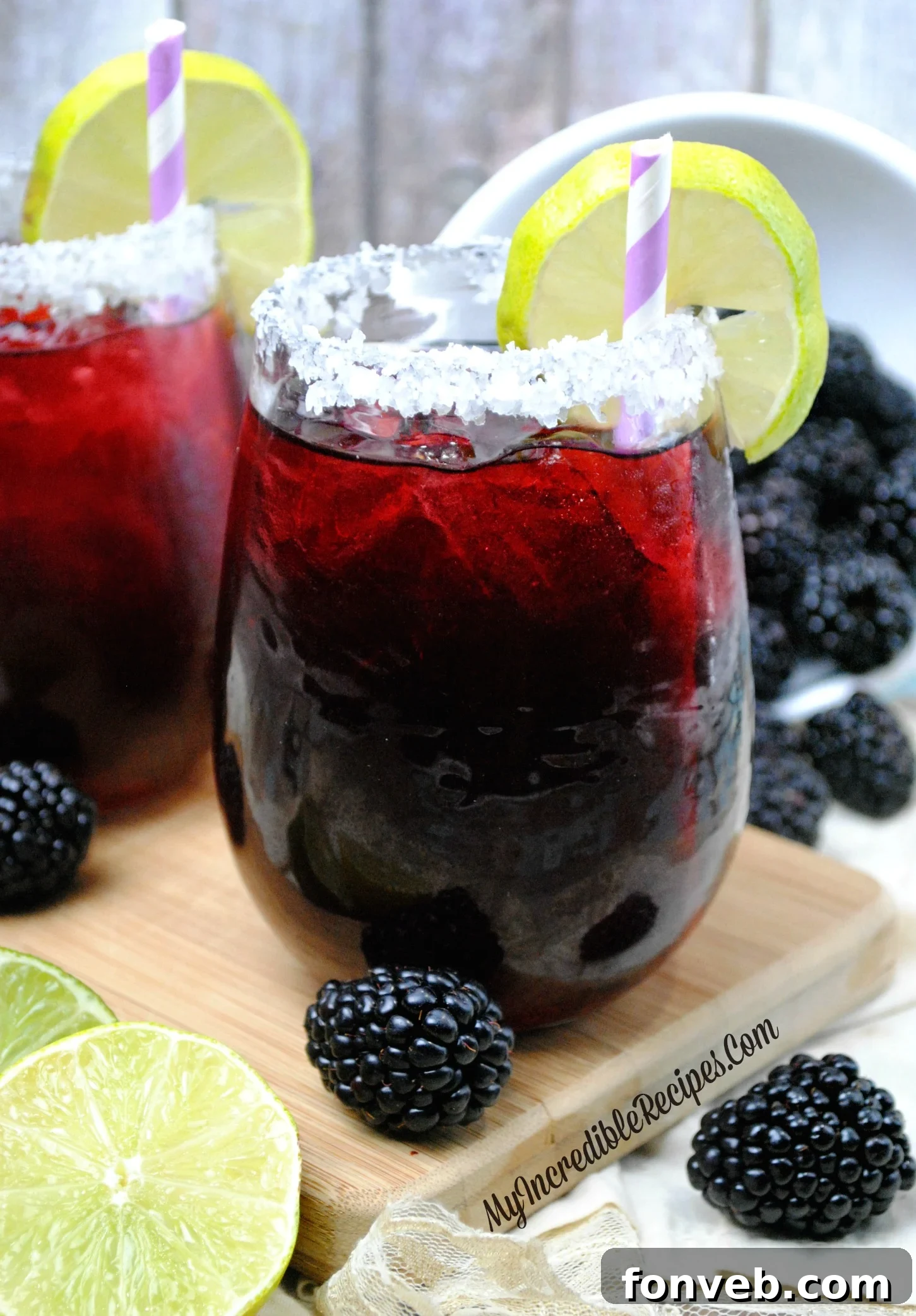 Close-up of a Blackberry Margarita cocktail with a salted rim and lime garnish
