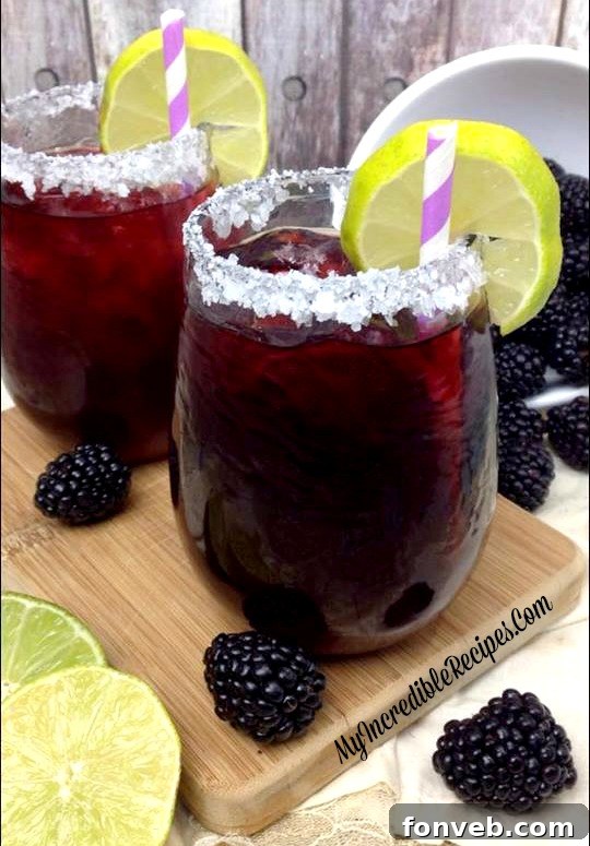 Glass of Blackberry Margarita with ice and lime slice