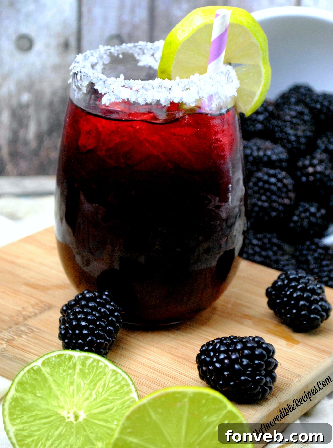 Overhead shot of two Blackberry Margaritas with a bowl of fresh blackberries