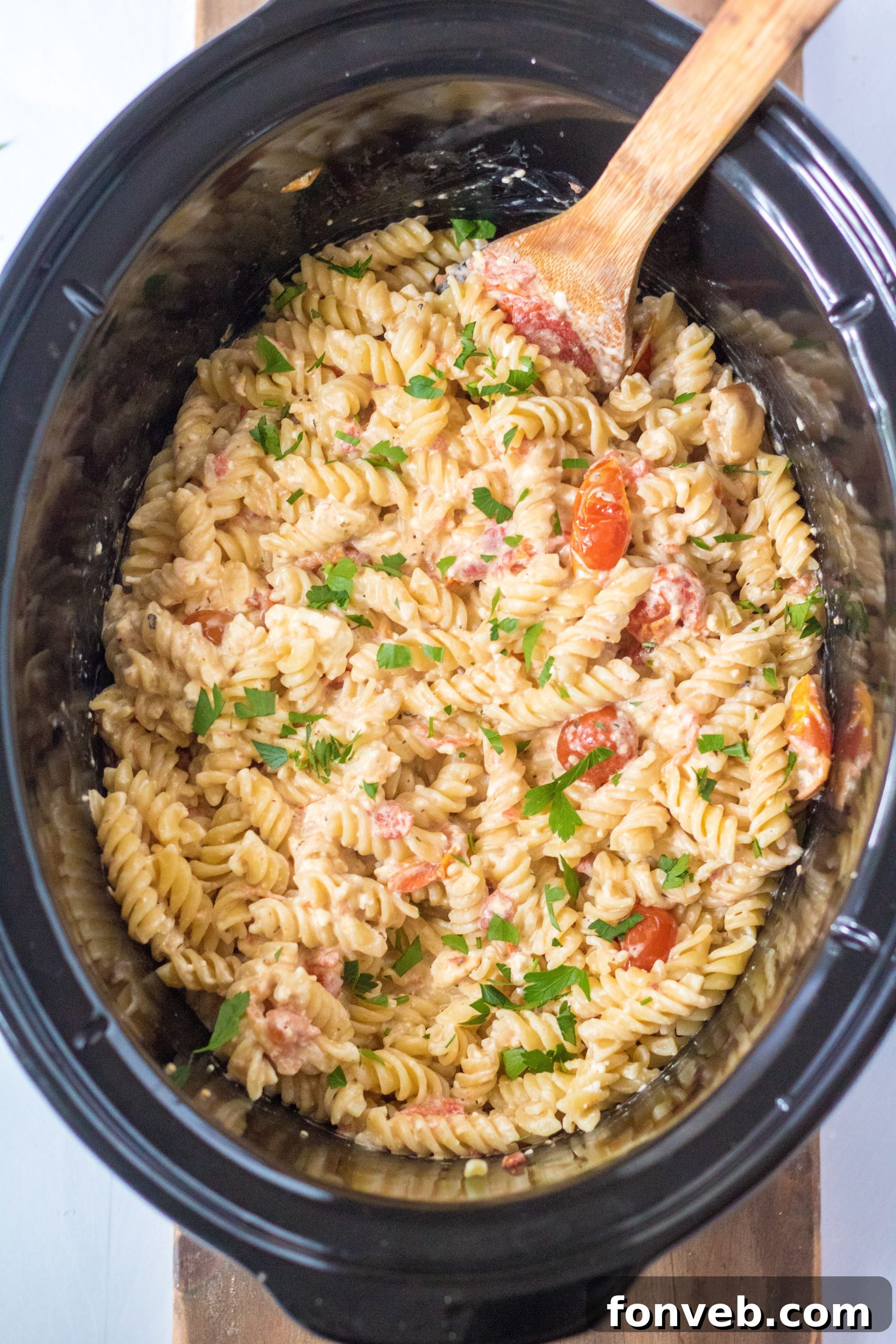 A vibrant bowl of Slow Cooker Tomato and Feta Pasta, garnished with fresh basil, showcasing the creamy sauce and perfectly cooked rotini.