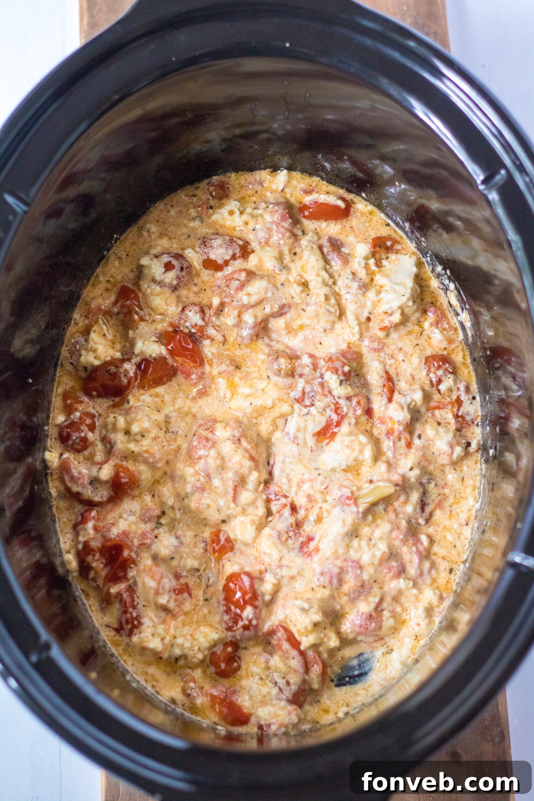 The Slow Cooker Tomato and Feta Pasta served in a bowl, with a fork twirled in the creamy sauce and pasta.