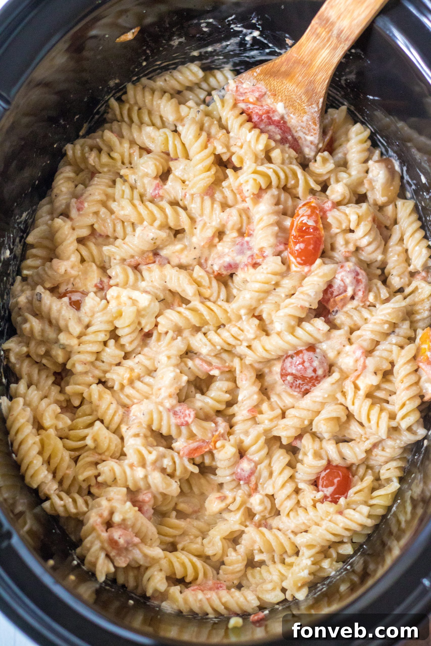 The slow cooker filled with the creamy Tomato and Feta Pasta after stirring, ready for serving.