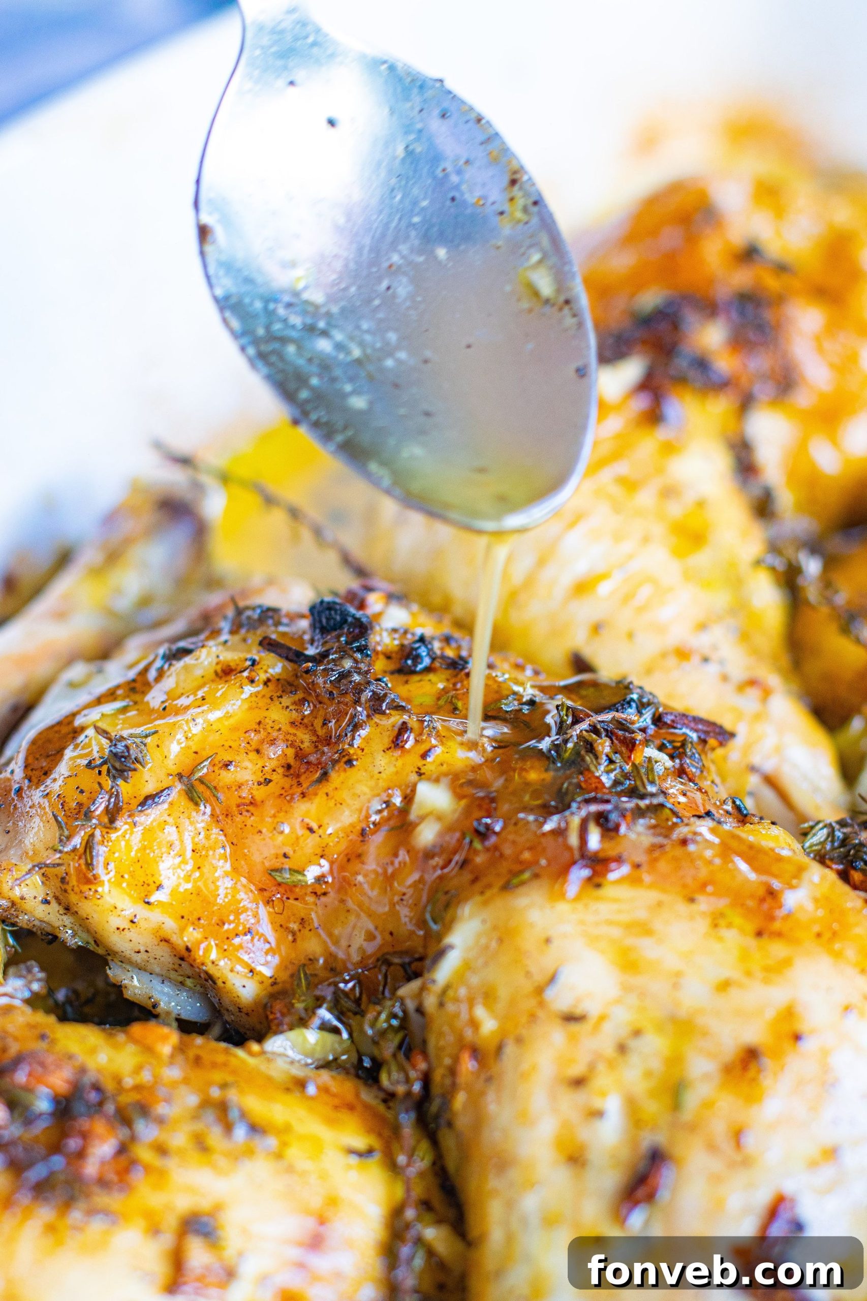 Close-up of a perfectly baked garlic butter chicken thigh, showing crispy skin and succulent meat.