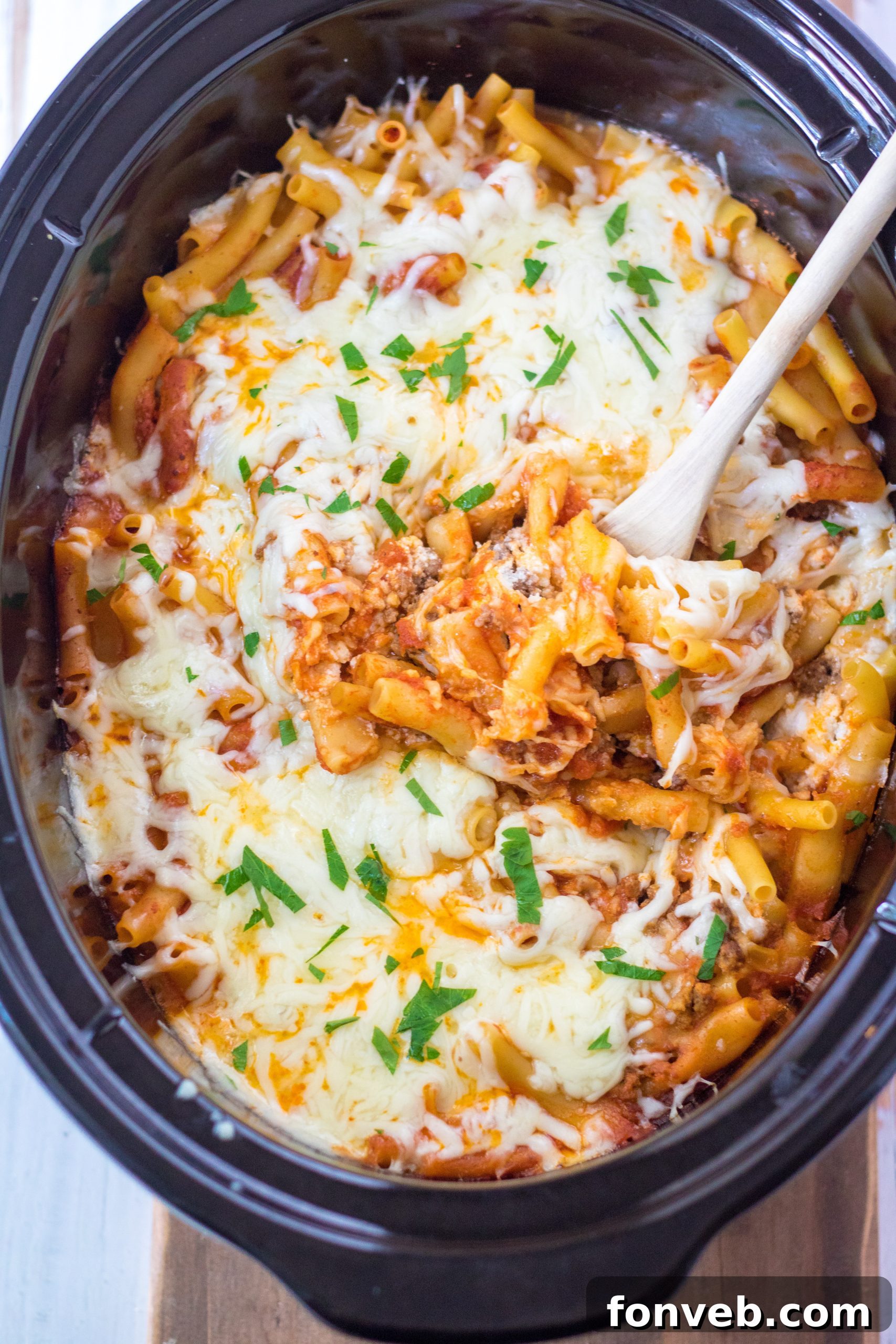 Delicious Slow Cooker Cheesy Baked Ziti dish topped with melted mozzarella cheese and fresh parsley, ready to serve.