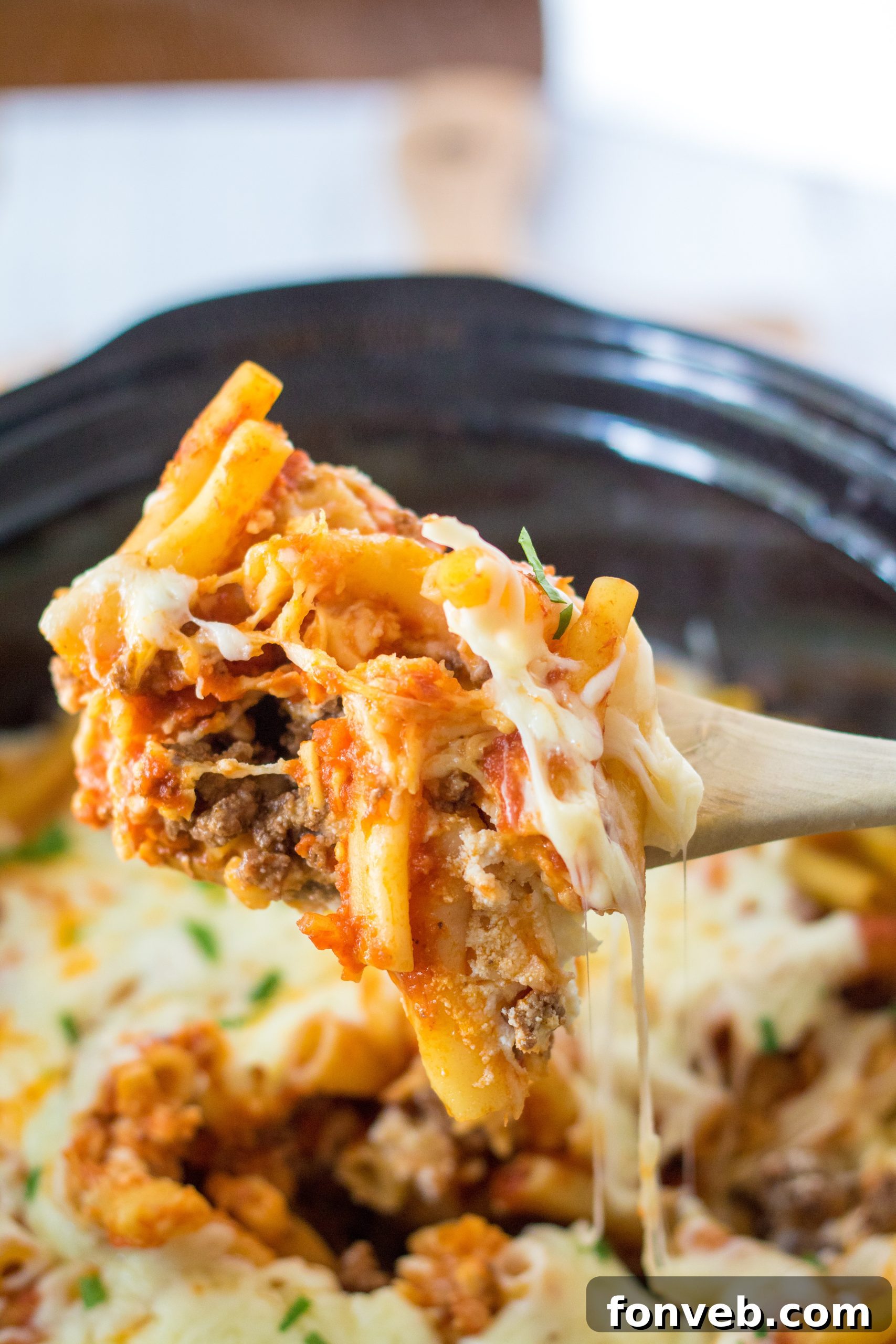 A full Slow Cooker Cheesy Baked Pasta dish garnished with fresh basil, ready for a family meal.
