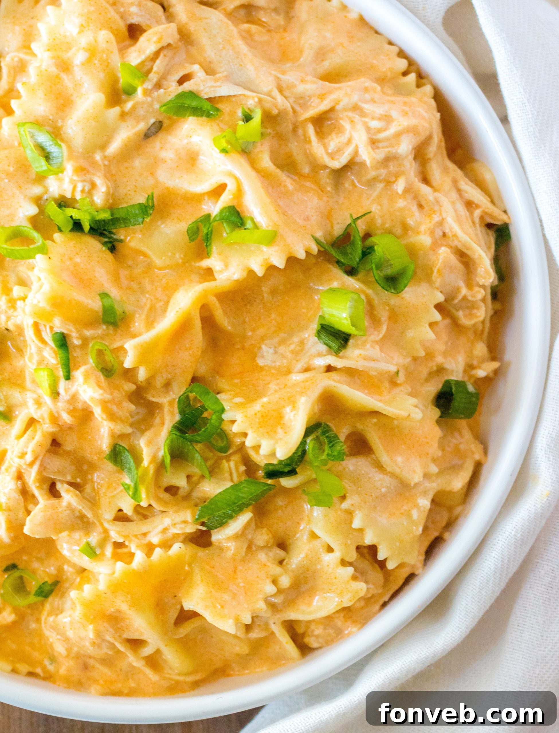 A slow cooker on a kitchen counter with buffalo chicken pasta inside.