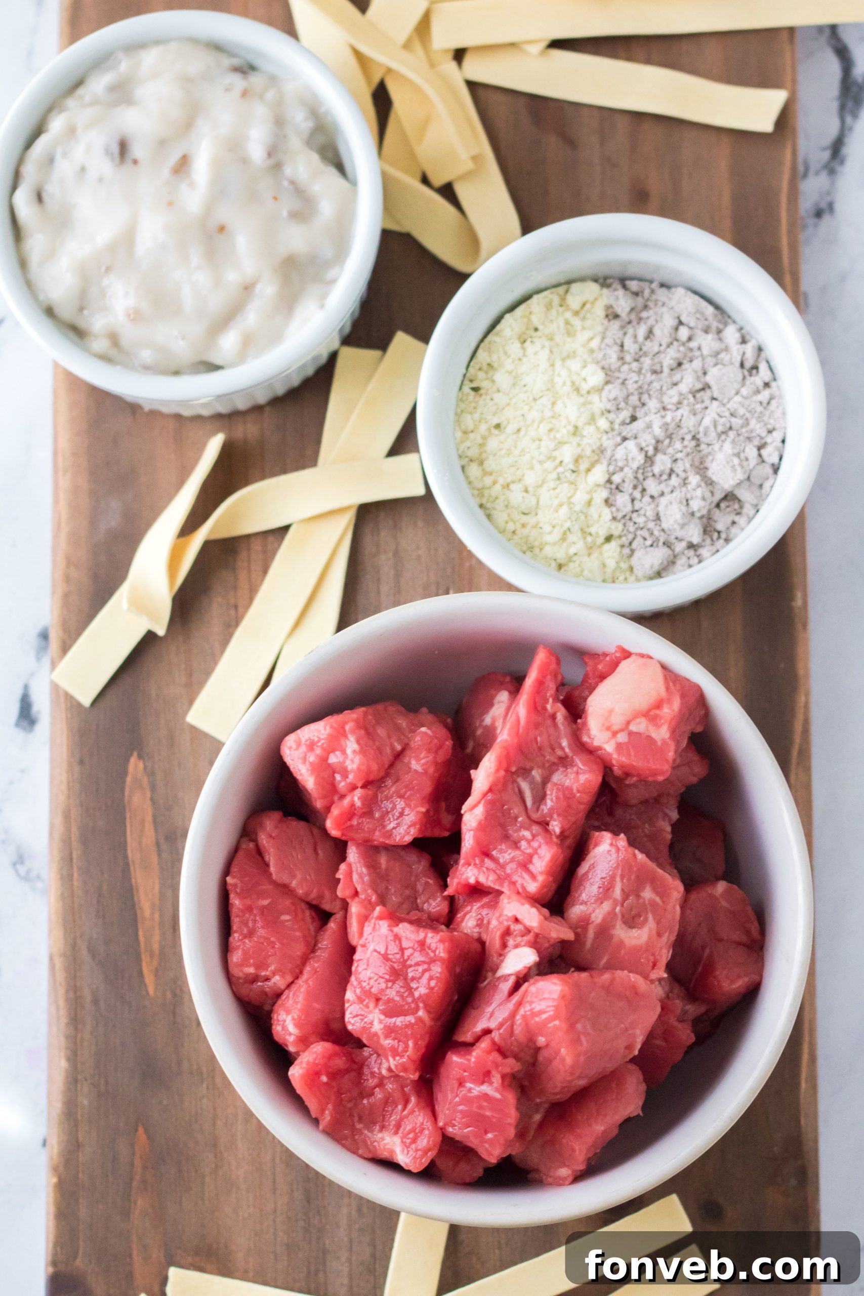 A close-up of tender beef chunks and noodles in a crock pot