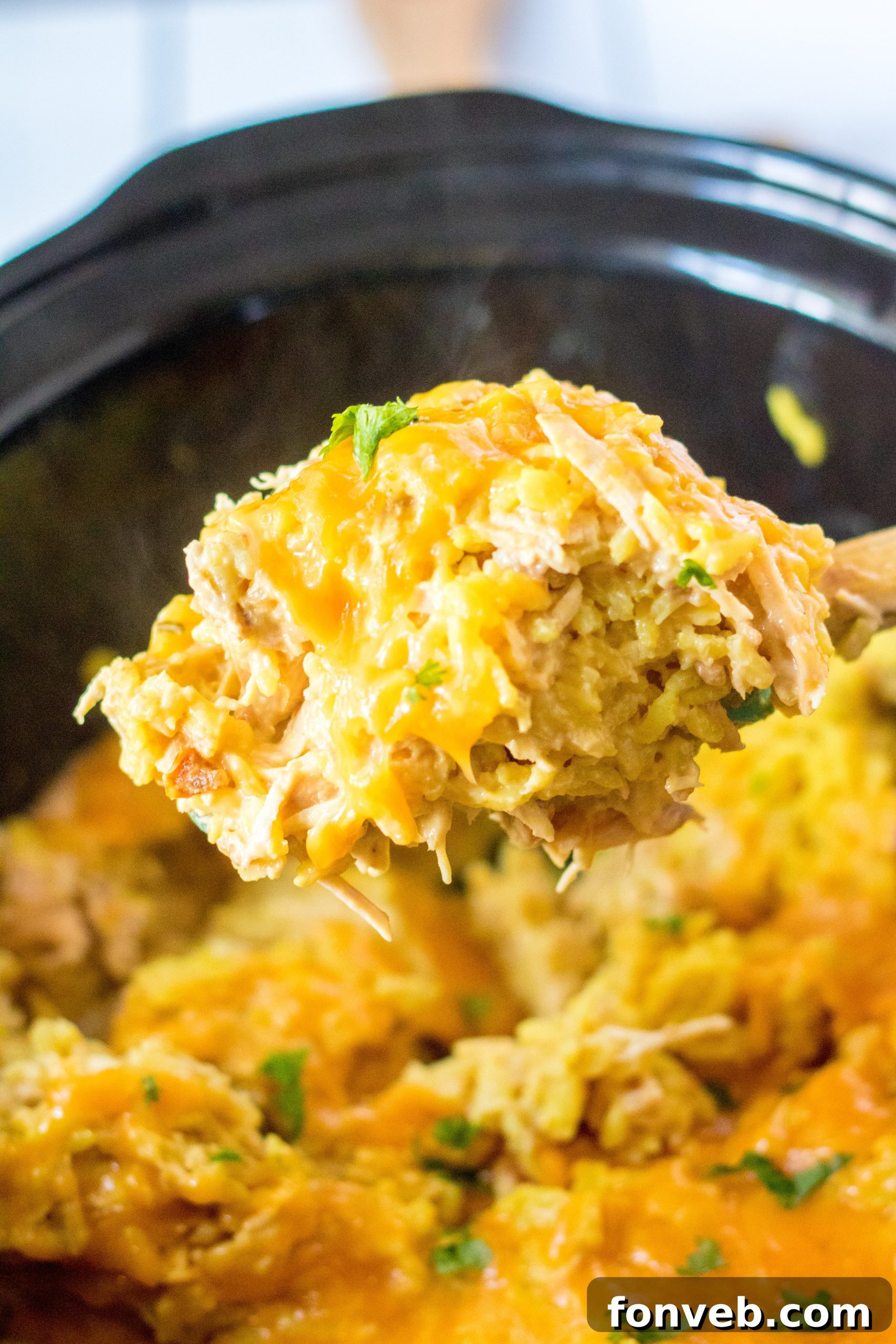 Slow Cooker Cheesy Chicken and Rice dish, served in a bowl, with a spoon.