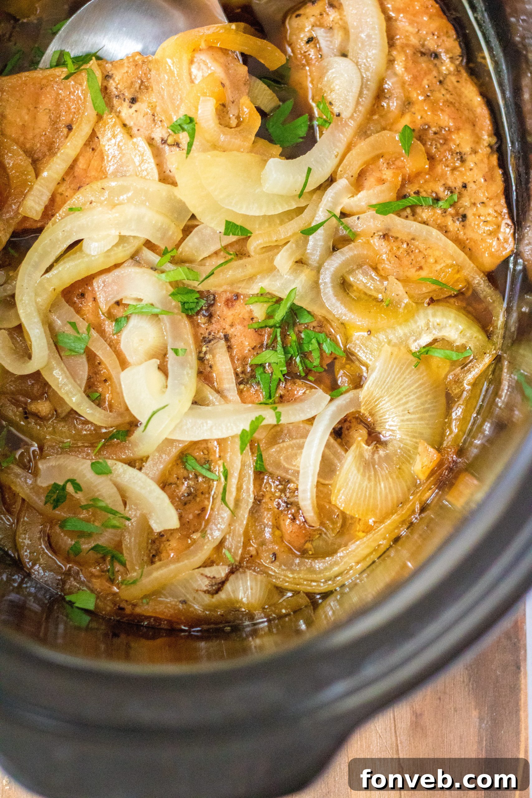 Serving dish with slow cooker pork chops and onions, ready to be plated