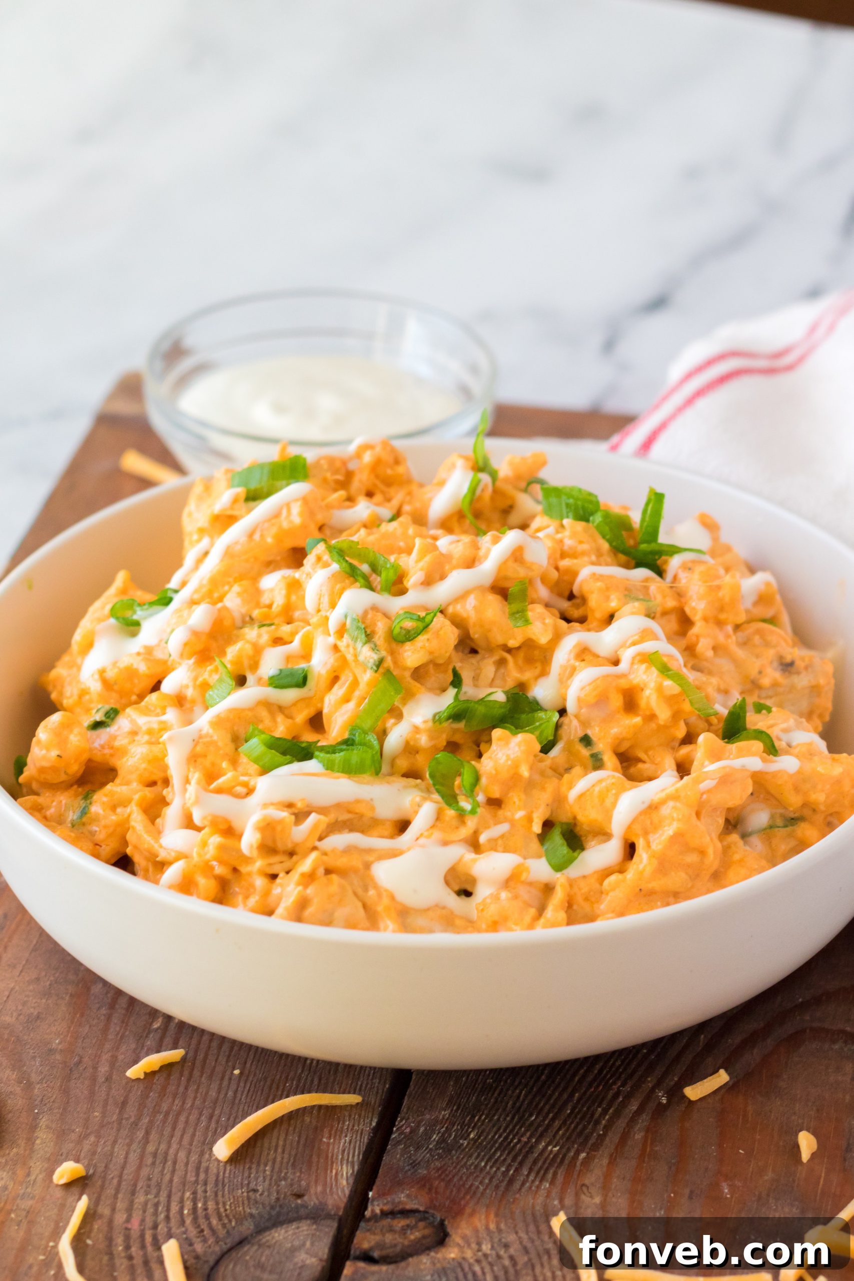 Tangy Slow Cooker Buffalo Chicken Mac and Cheese 9 Shredded cooked chicken, an essential ingredient for Buffalo Chicken Mac & Cheese.