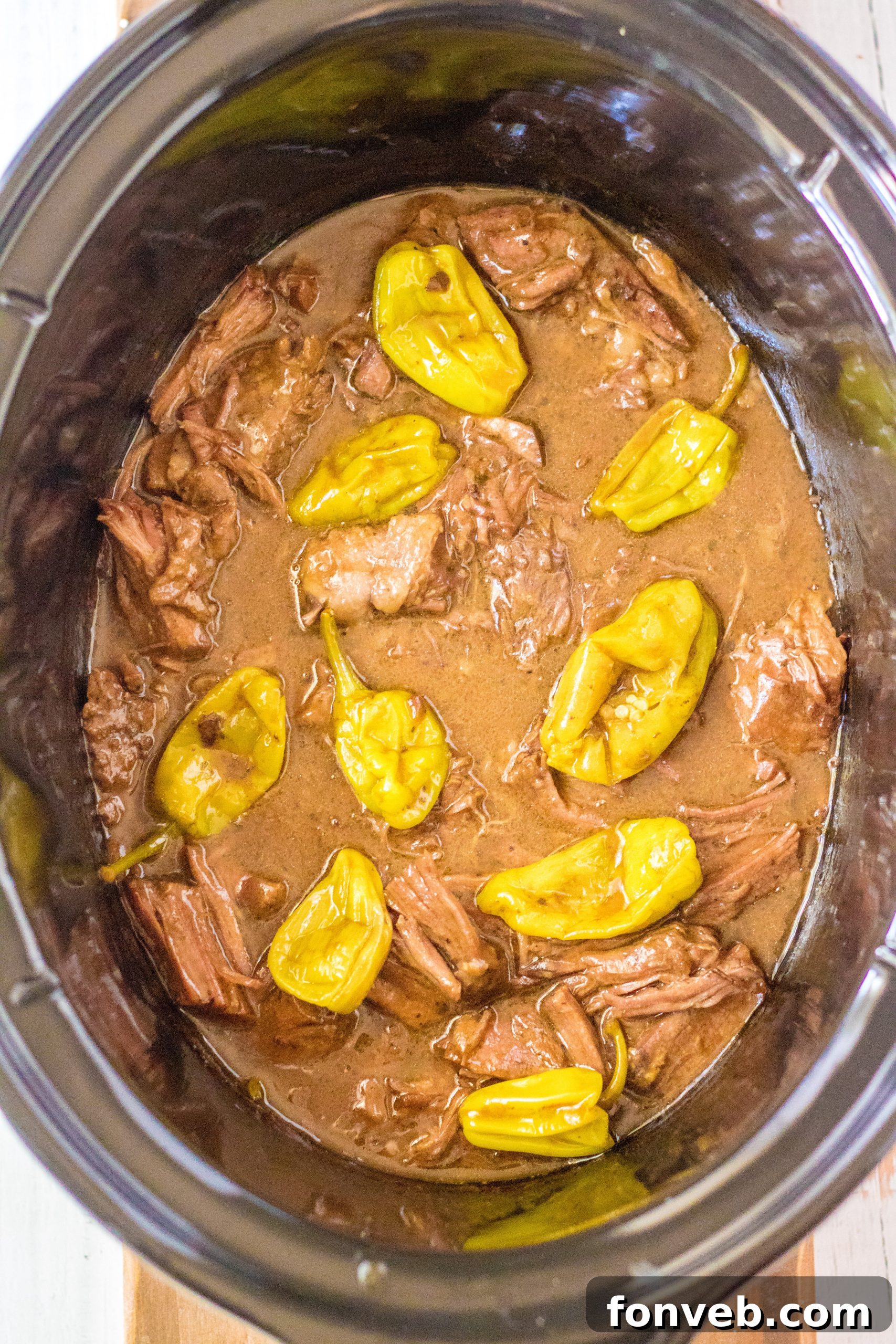 Melt-in-Your-Mouth Slow Cooker Mississippi Pot Roast 5 Raw ingredients for Mississippi Pot Roast laid out next to a slow cooker.