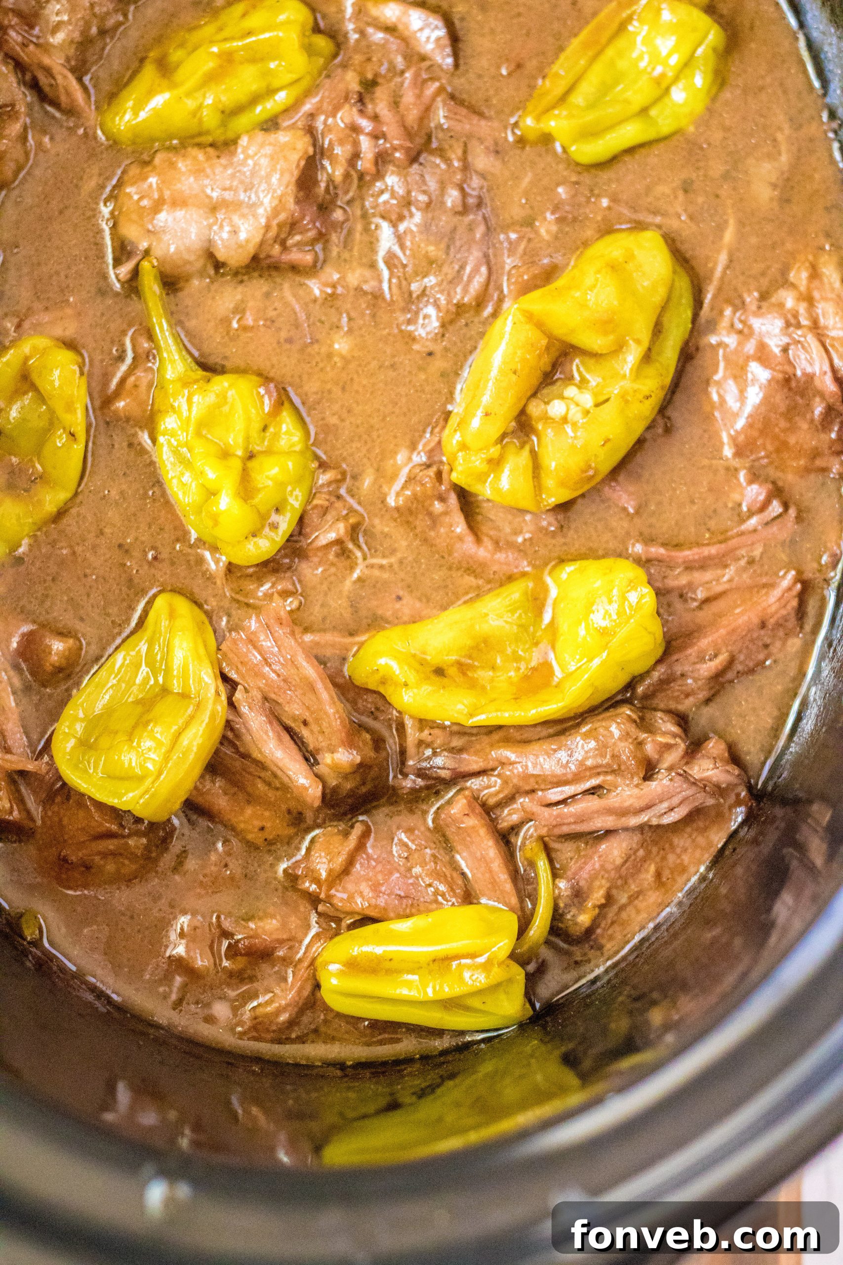 Melt-in-Your-Mouth Slow Cooker Mississippi Pot Roast 6 Slow Cooker Mississippi Pot Roast simmering in a crock pot.