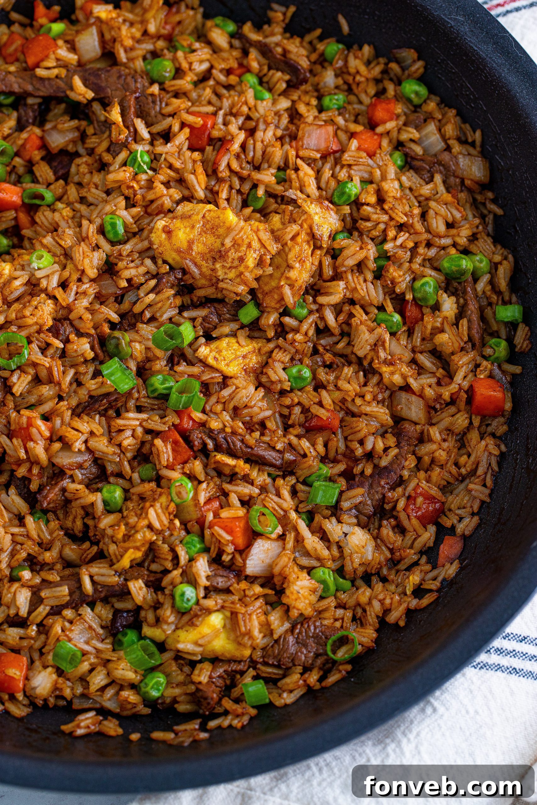 A beautifully presented bowl of Beef Fried Rice with a spoon, inviting a taste.