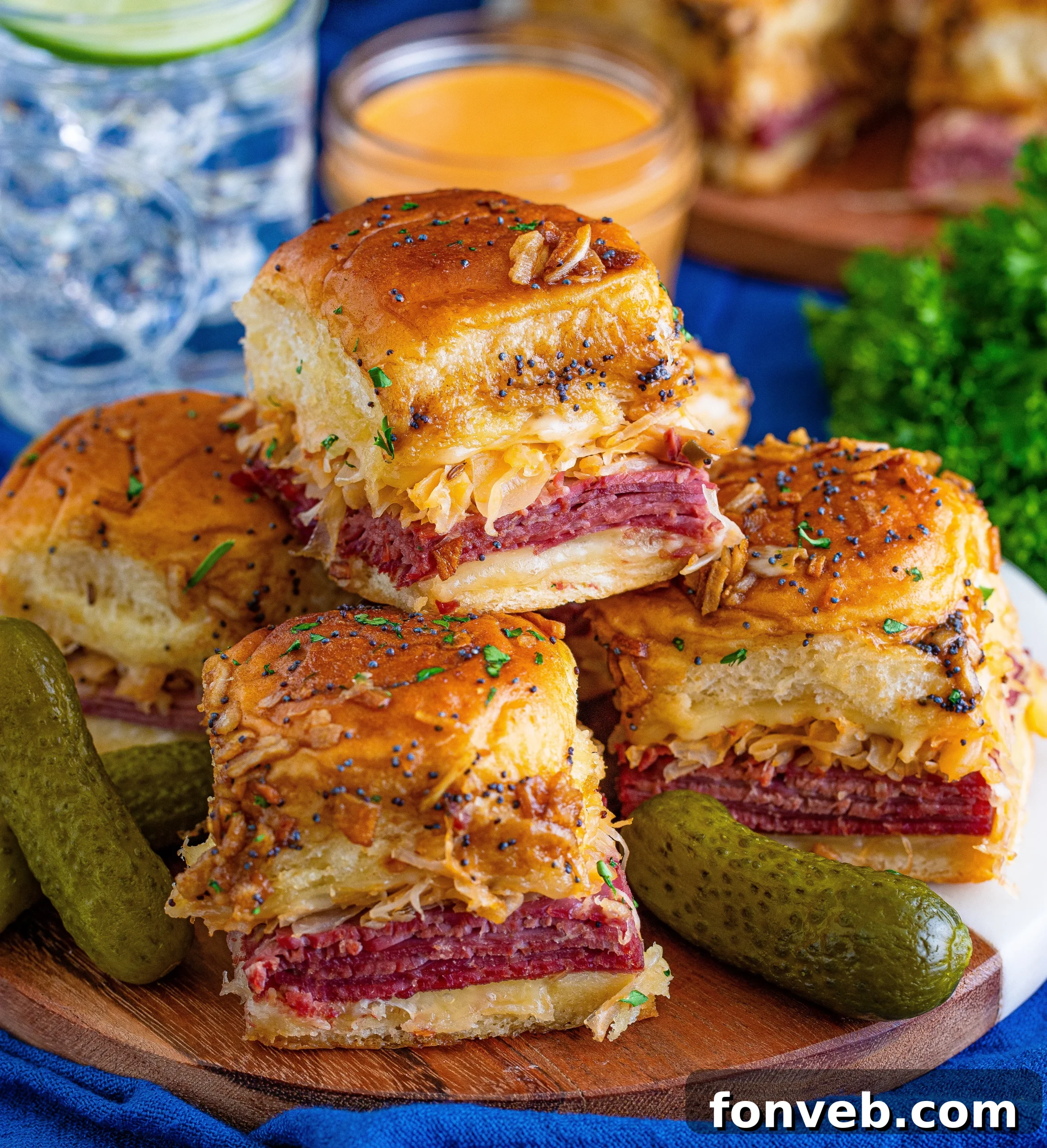 Platter of golden-brown Reuben Sliders, with the cheesy interior visible.