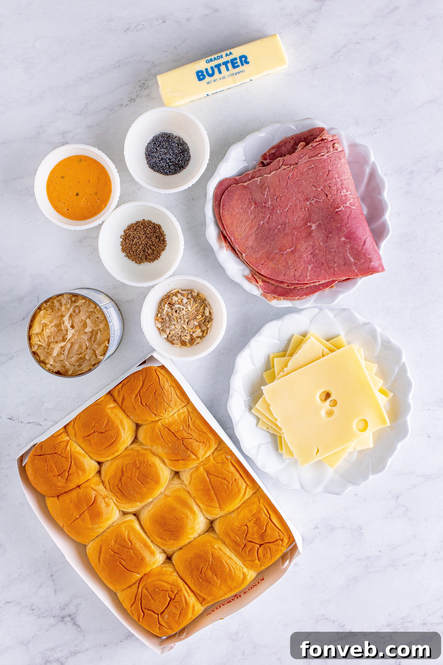 A tray of freshly baked Reuben Sliders, with melted cheese and a golden crust.