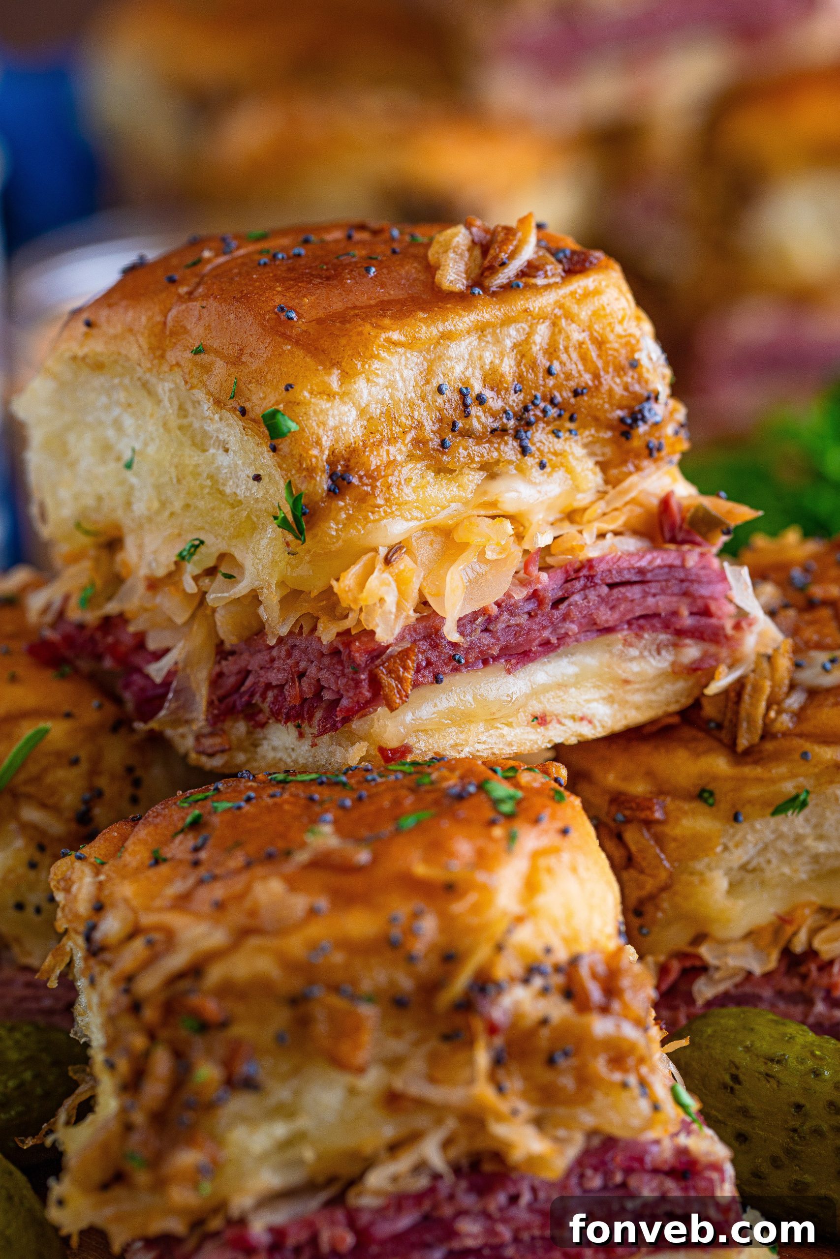 A cutting board with baked Reuben Sliders, sliced and ready for serving.