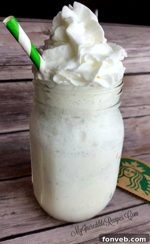 A close-up of a homemade Vanilla Bean Frappuccino with generous whipped cream.