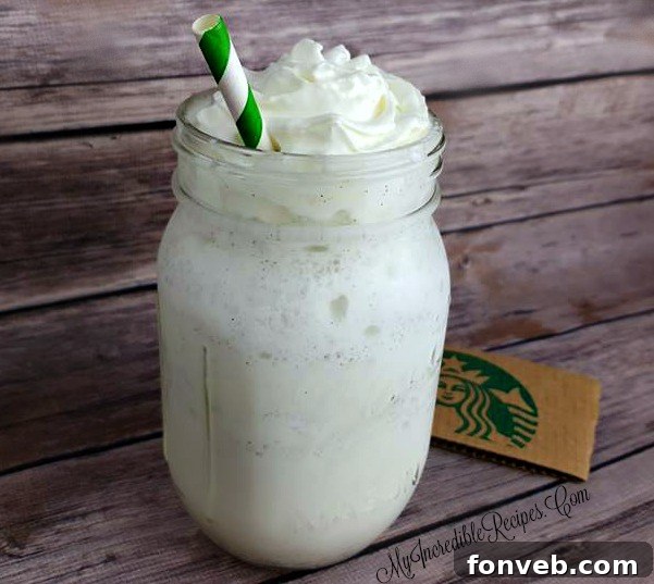 A hand holding a glass of homemade Frappuccino, showing its delicious texture.