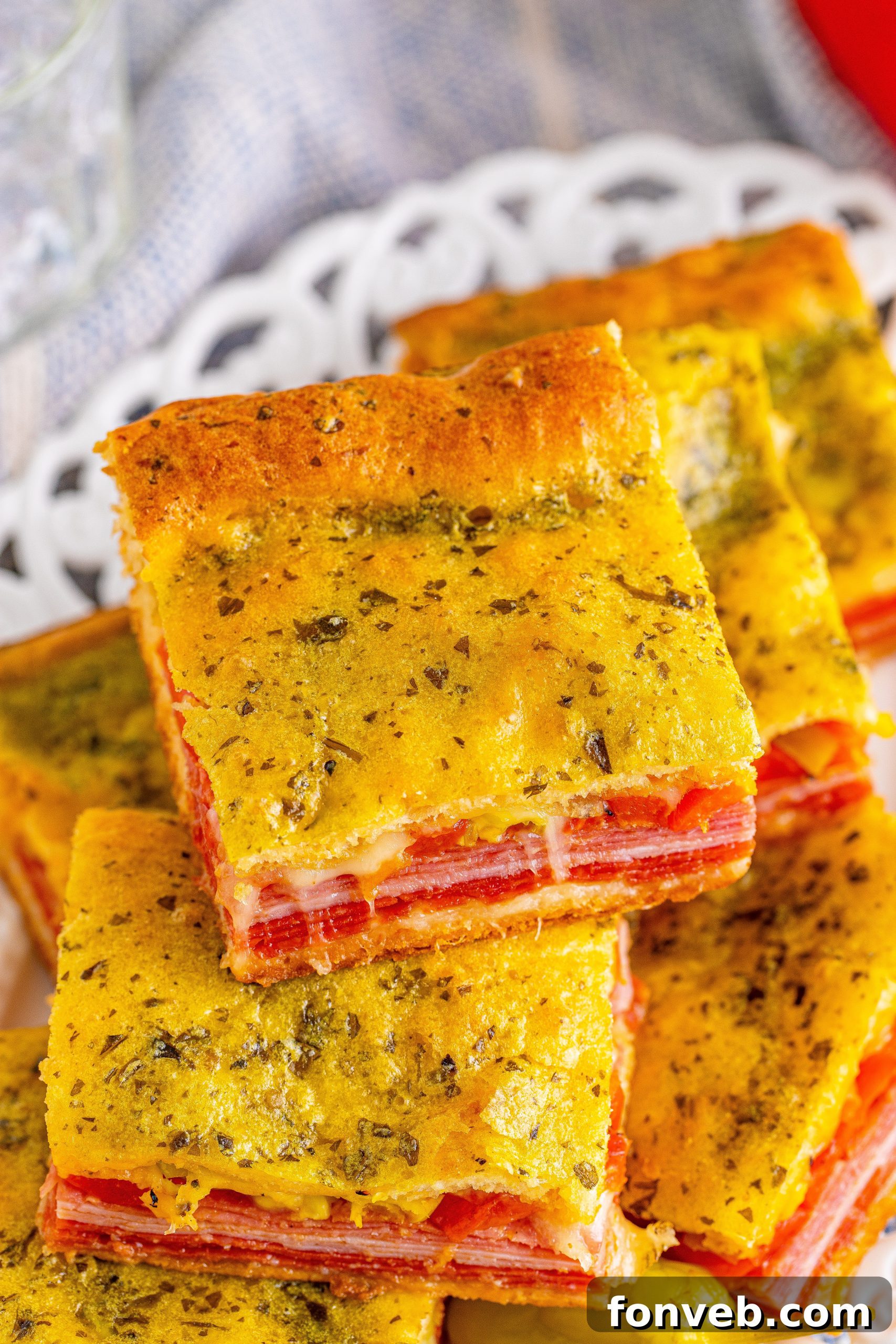 Individual Italian Antipasto Squares served on a wooden board, showcasing the layers.