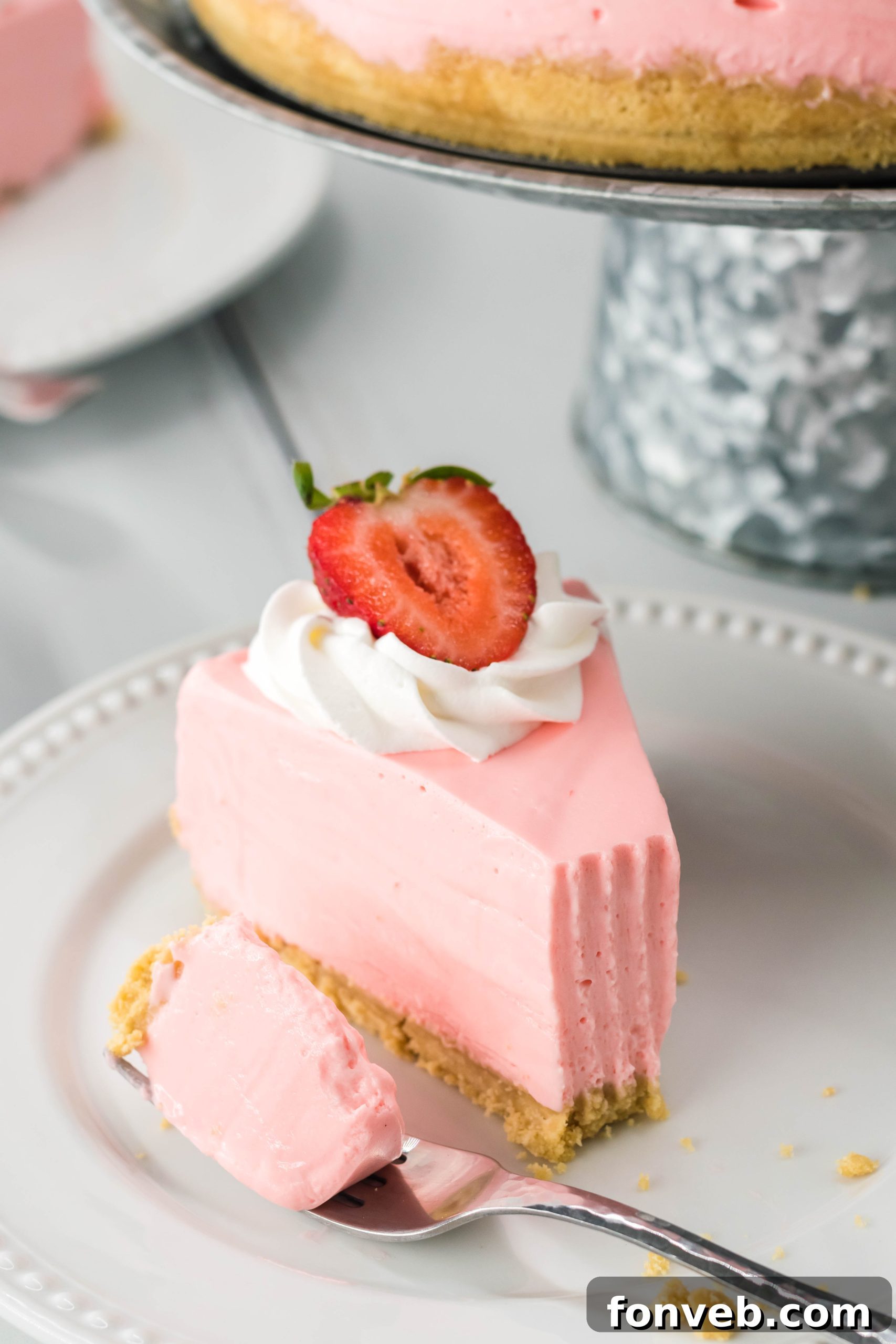 Luscious No-Bake Strawberry Cheesecake 4 Close-up of a No Bake Strawberry Cheesecake with a perfect slice removed, highlighting its creamy layers.