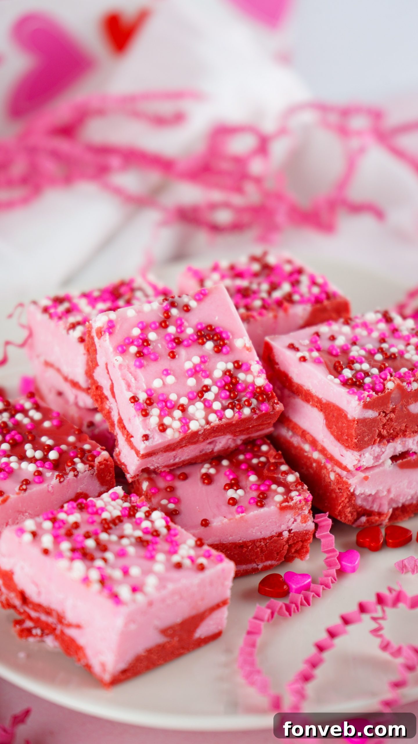 A hand holding a piece of strawberry fudge