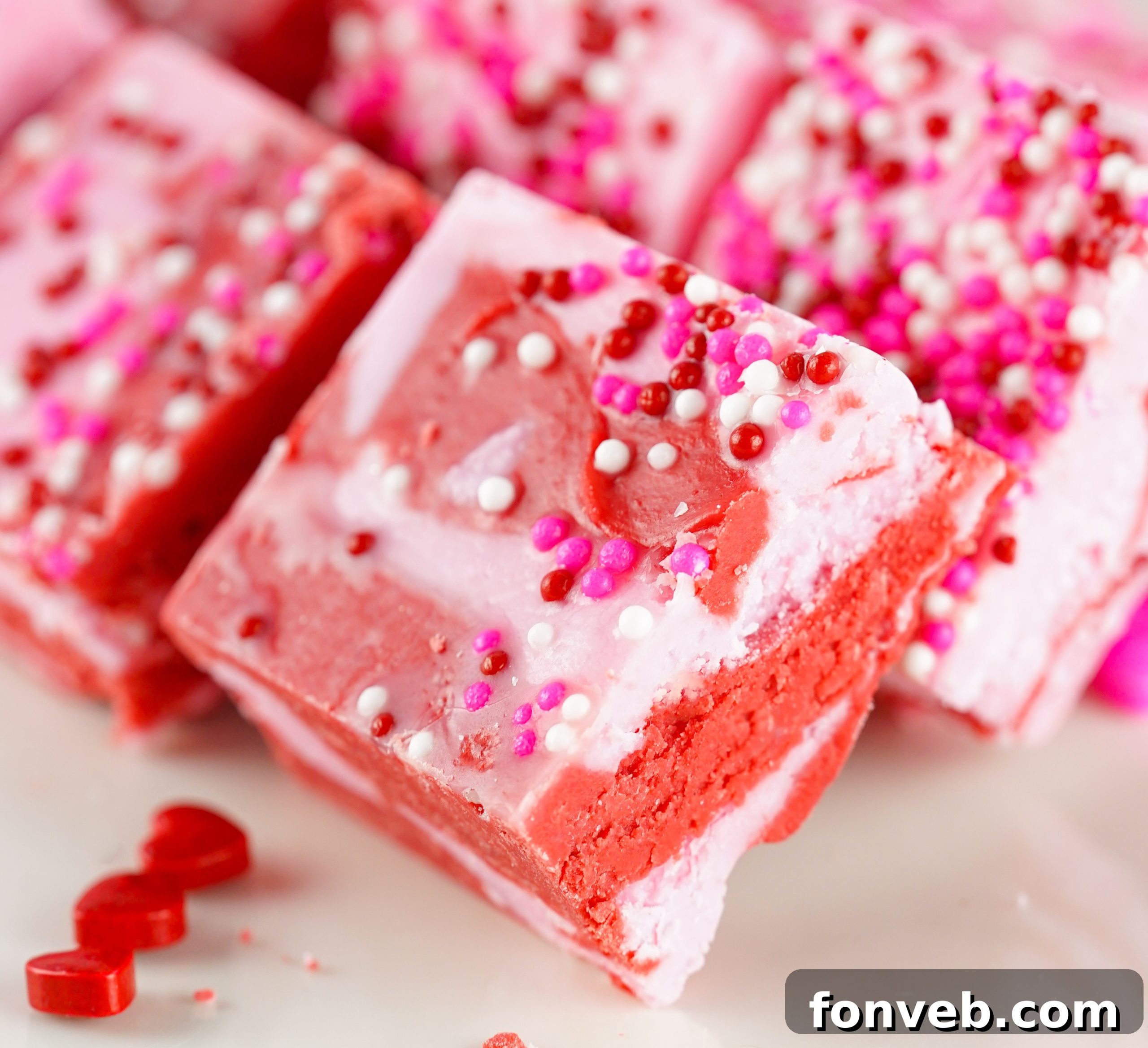 A block of strawberry fudge with sprinkles, ready to be cut