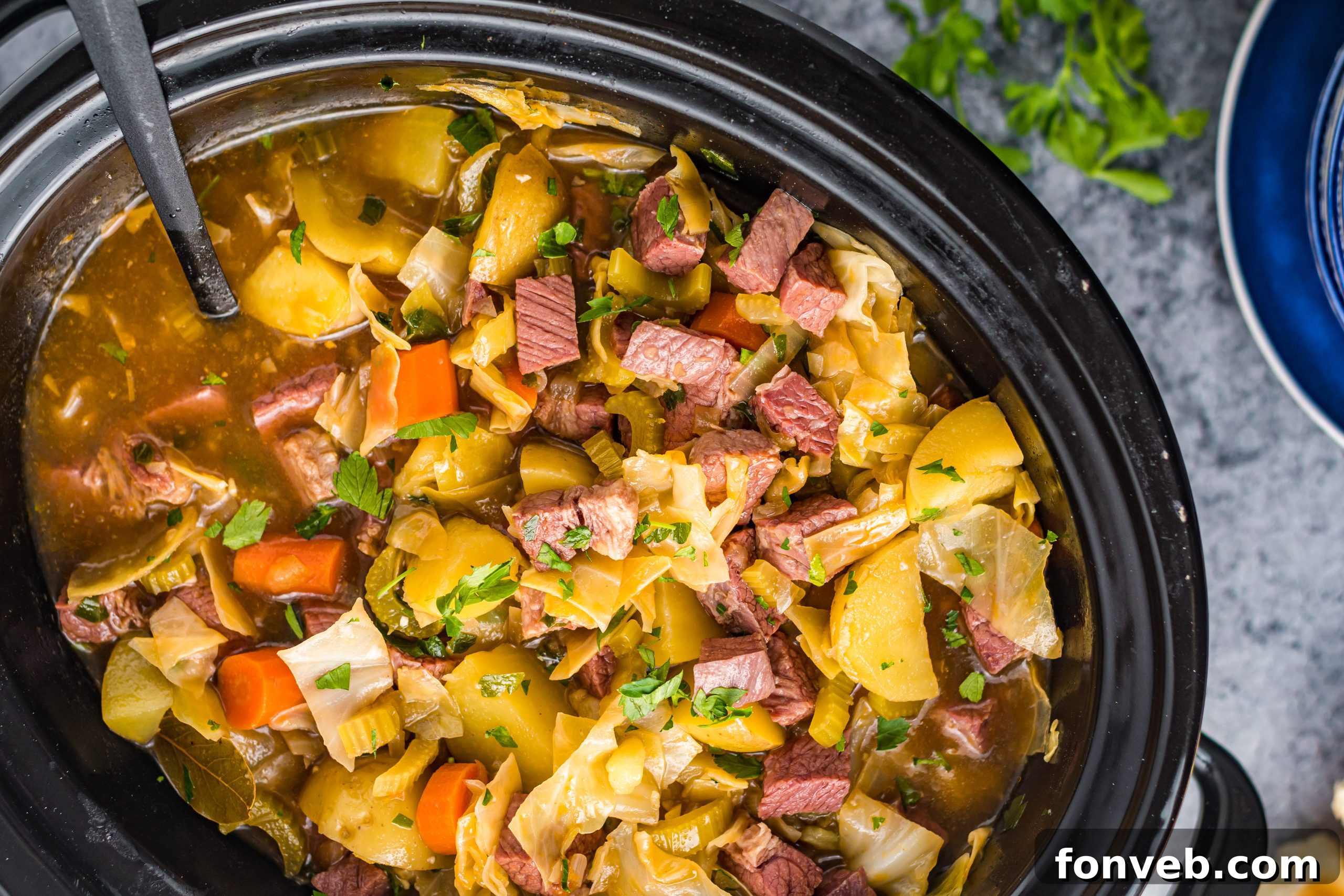 Slow Cooker Corned Beef and Cabbage Soup with various ingredients on a board