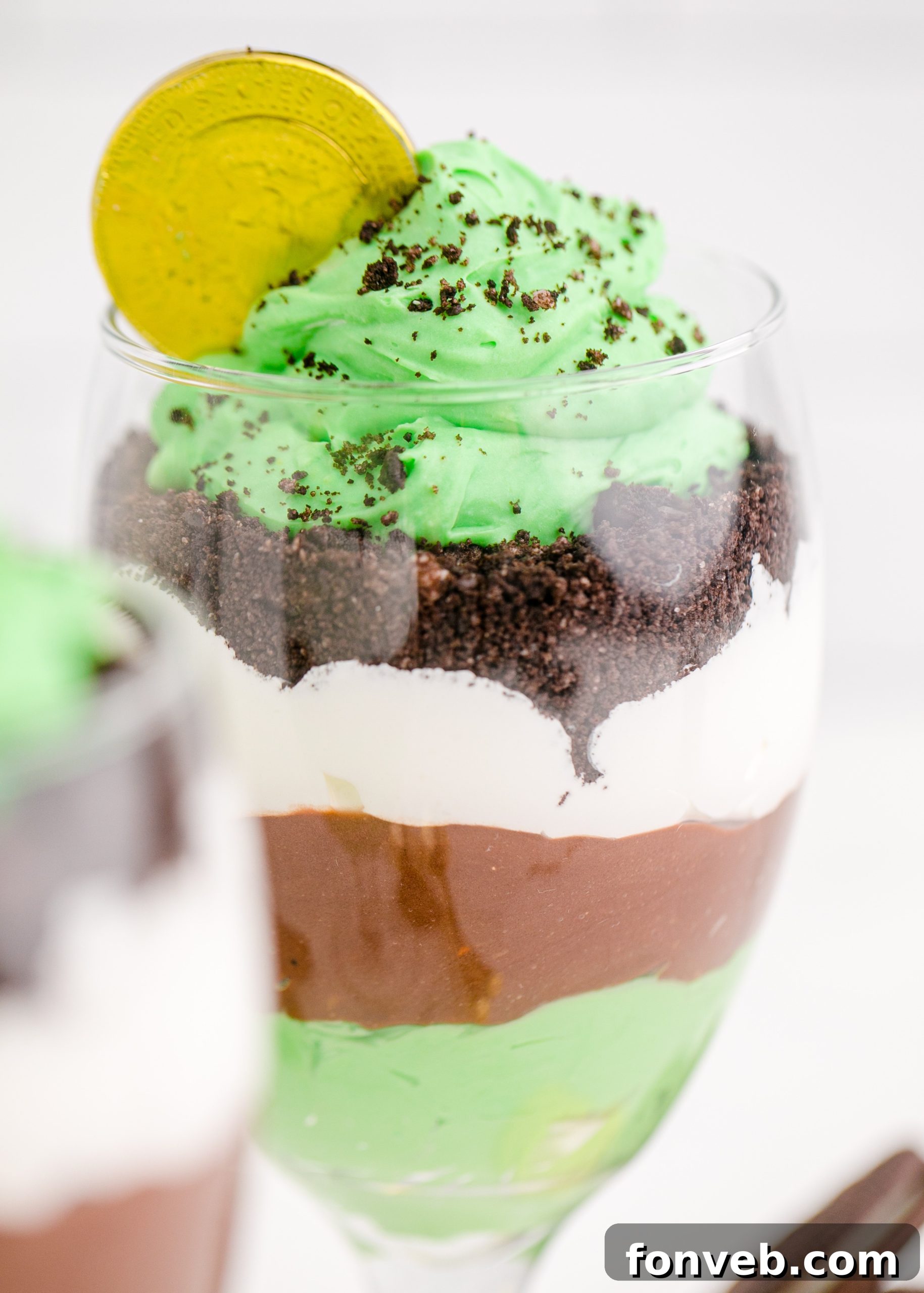 Stacked St. Patrick's Day Pudding Cups with green pudding and sprinkles
