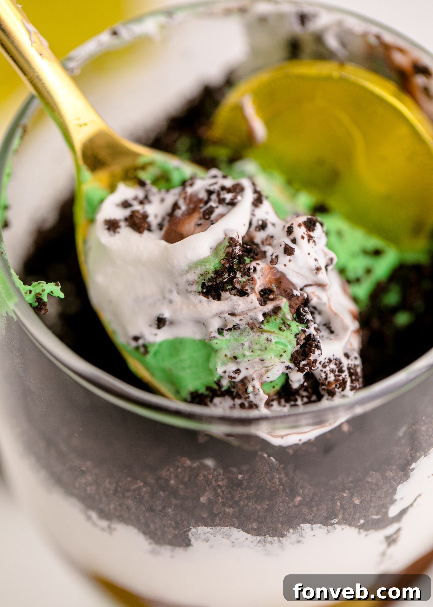 Close-up of three St. Patrick's Day Pudding Cups with various toppings including a gold coin, rainbow candy, and sprinkles